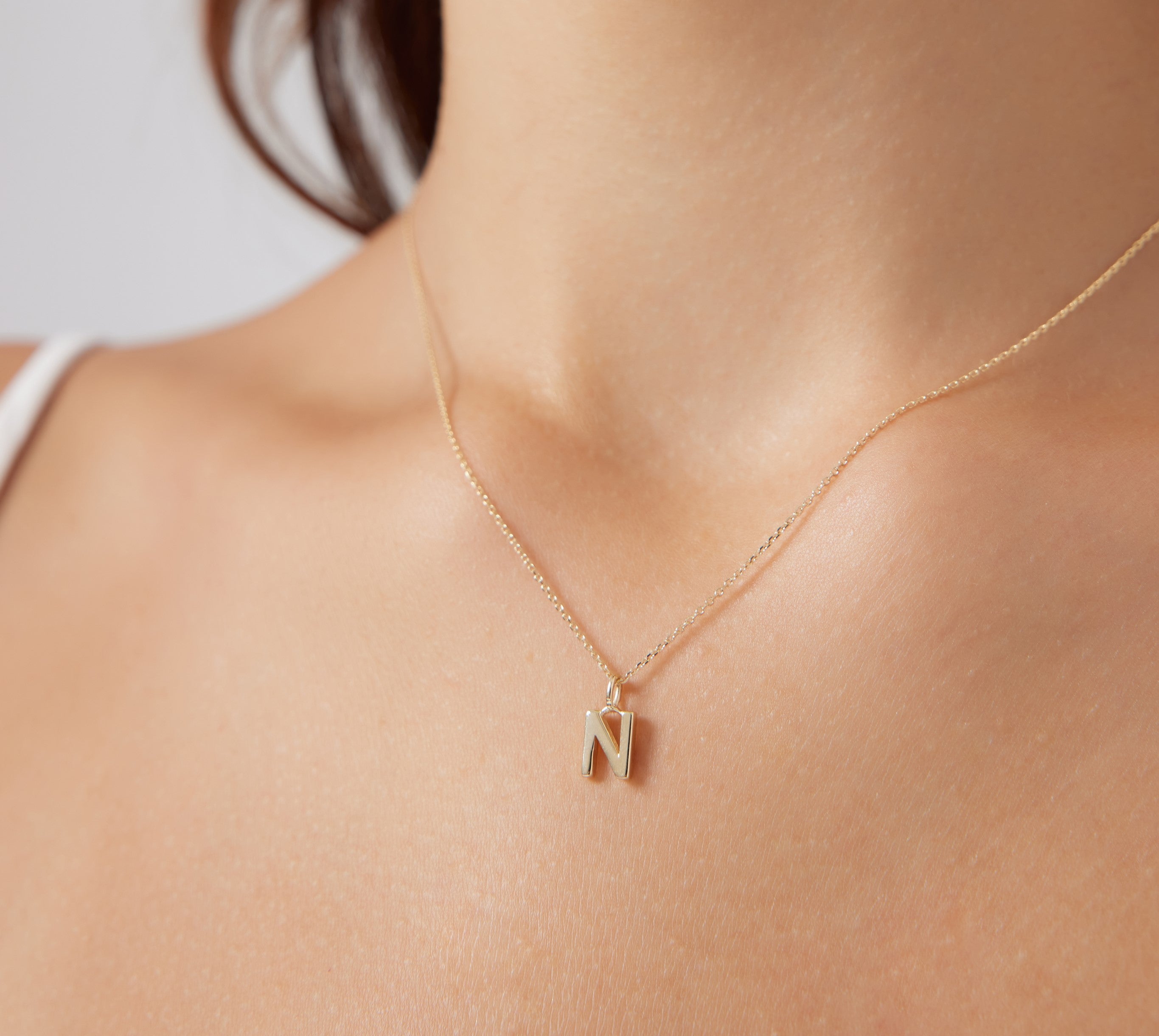 14K solid yellow gold initial necklace featuring letter N, delicate design perfect for everyday wear.