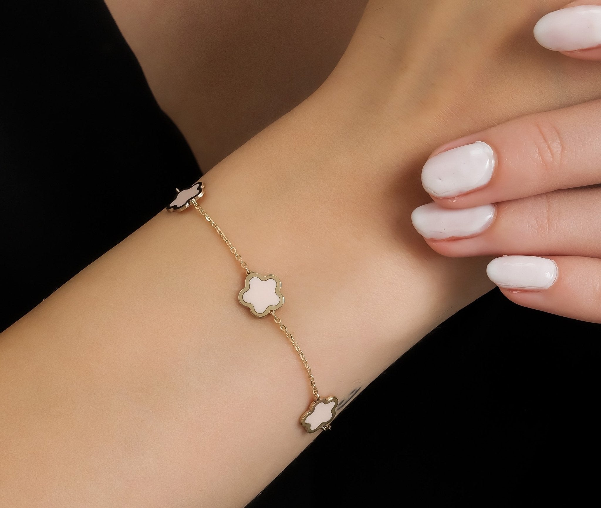 14K yellow gold pink blossom bracelet worn on wrist, featuring elegant flower motifs and a delicate chain design.