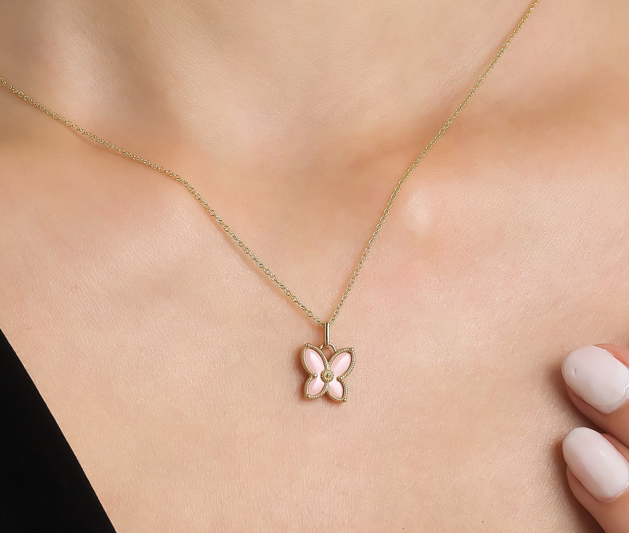 14K solid yellow gold butterfly necklace with pink enamel pendant worn on a model, perfect for everyday elegance.