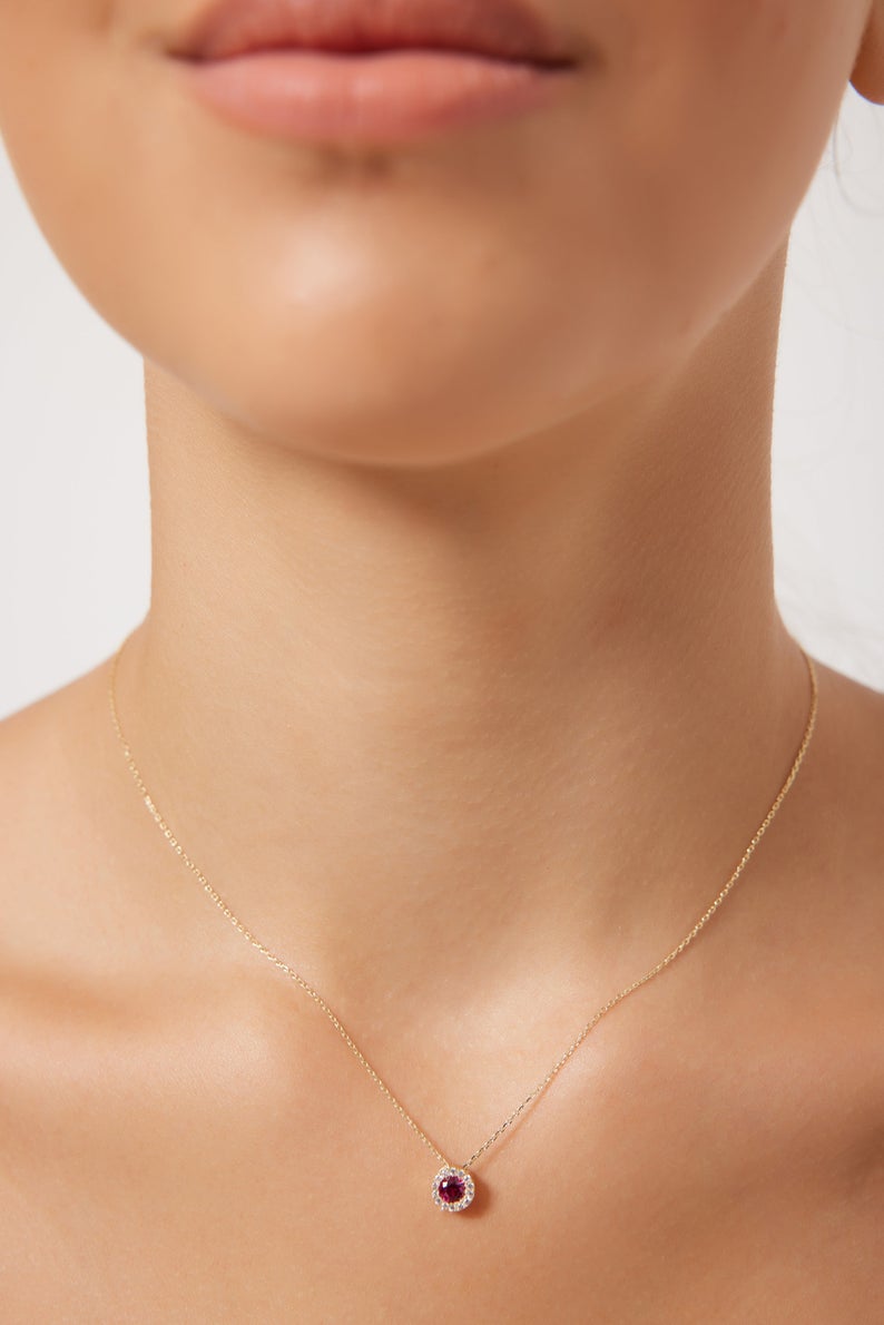 Model wearing a 14K solid yellow gold round solitaire ruby necklace with CZ, showcasing a delicate and minimalist design.