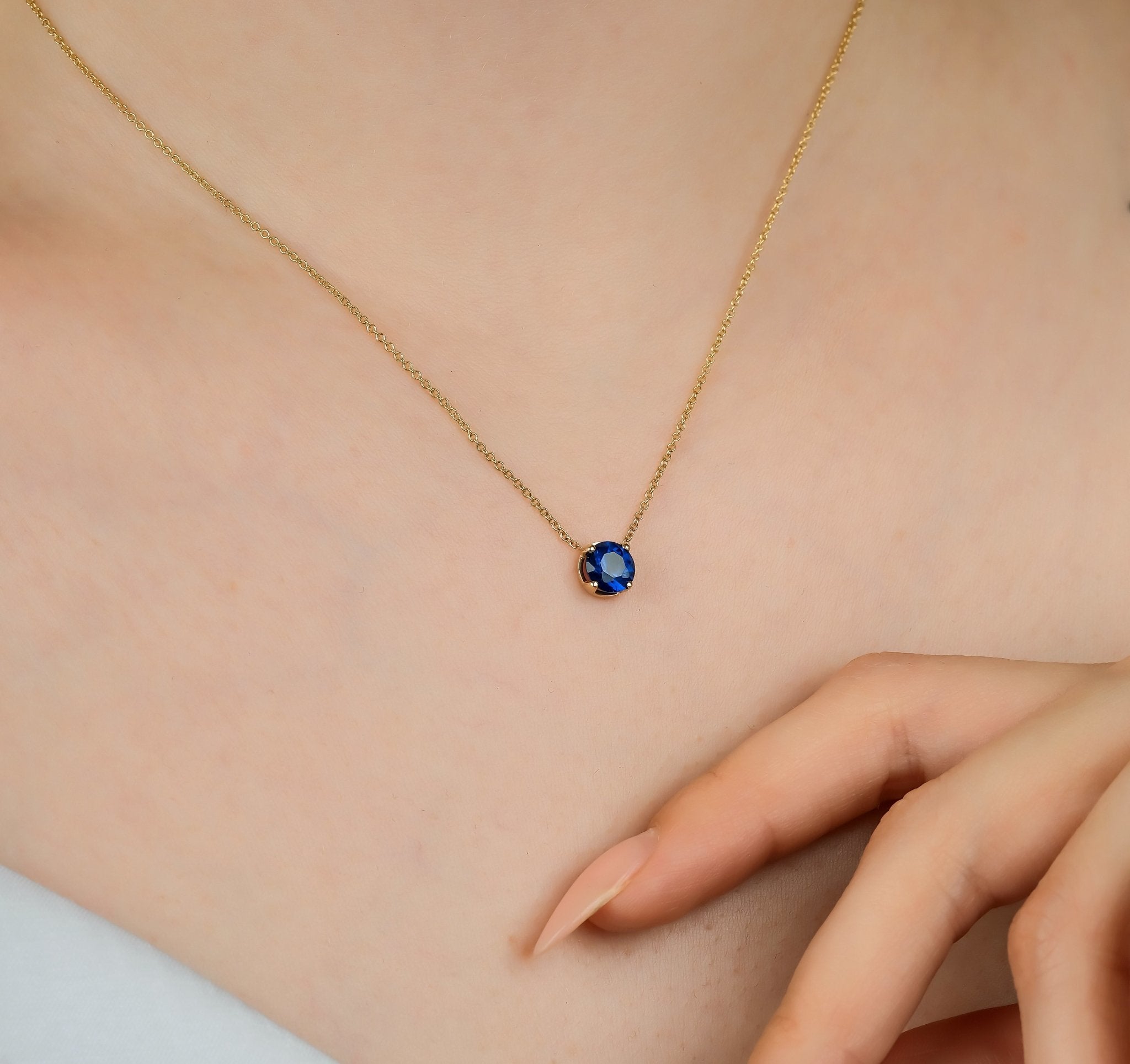 Minimalist 14K solid yellow gold necklace with a 6mm solitaire sapphire pendant, perfect for everyday wear.
