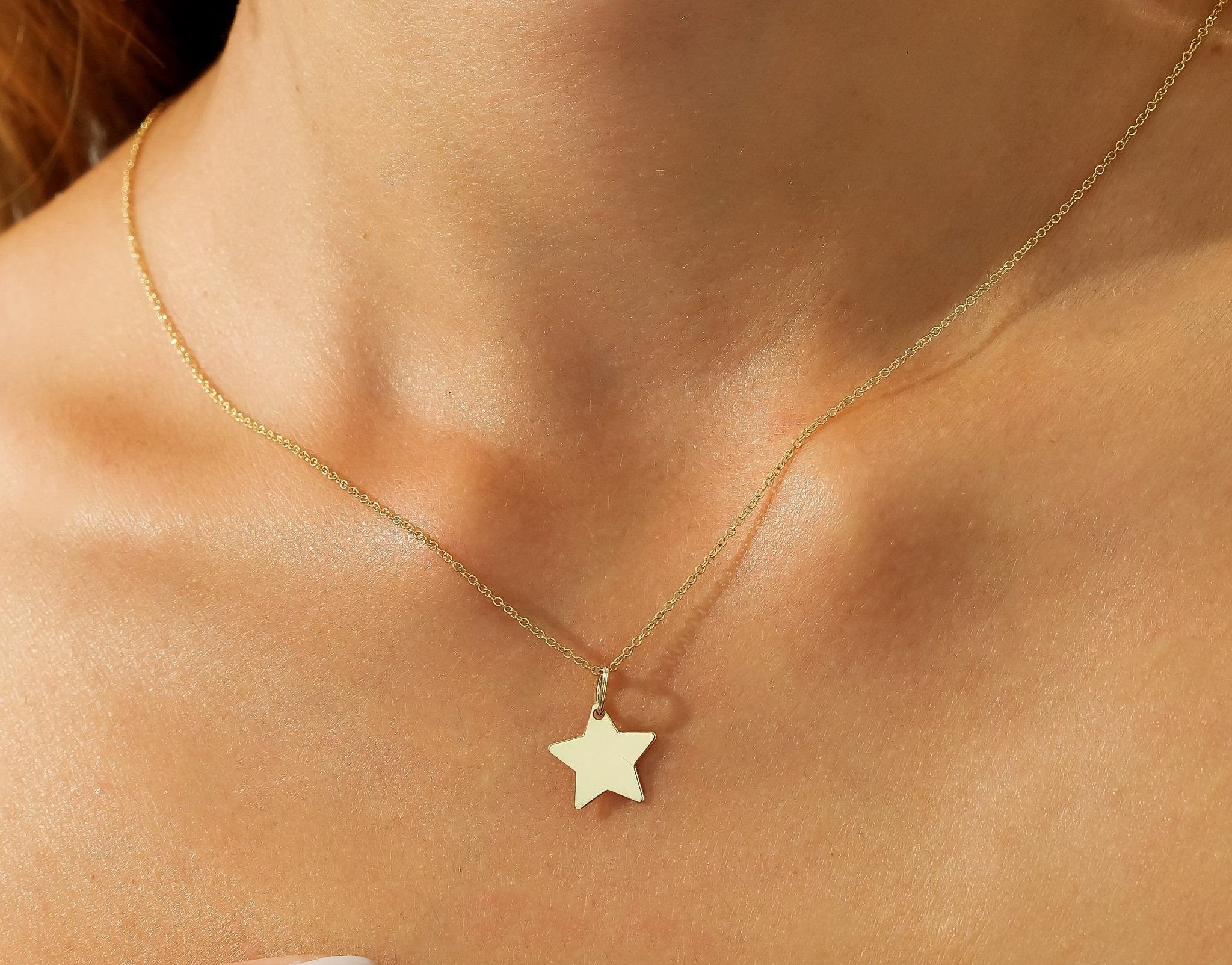 Dainty 14K solid yellow gold star necklace showcased on a model's neck, perfect for everyday wear.