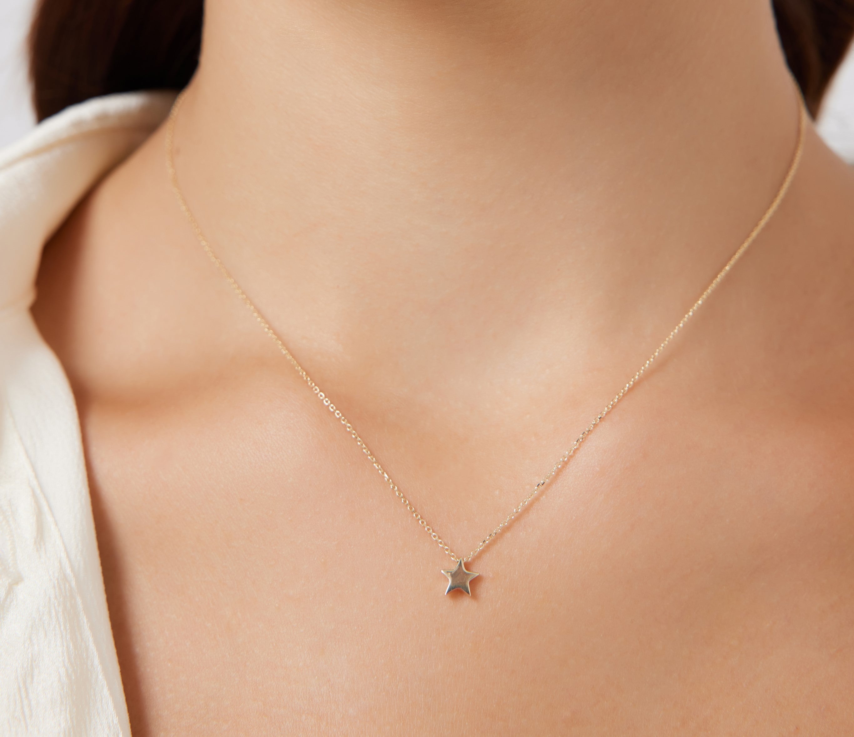 Dainty 14K solid yellow gold minimalist star necklace worn close-up on a woman's neckline, perfect for everyday use.