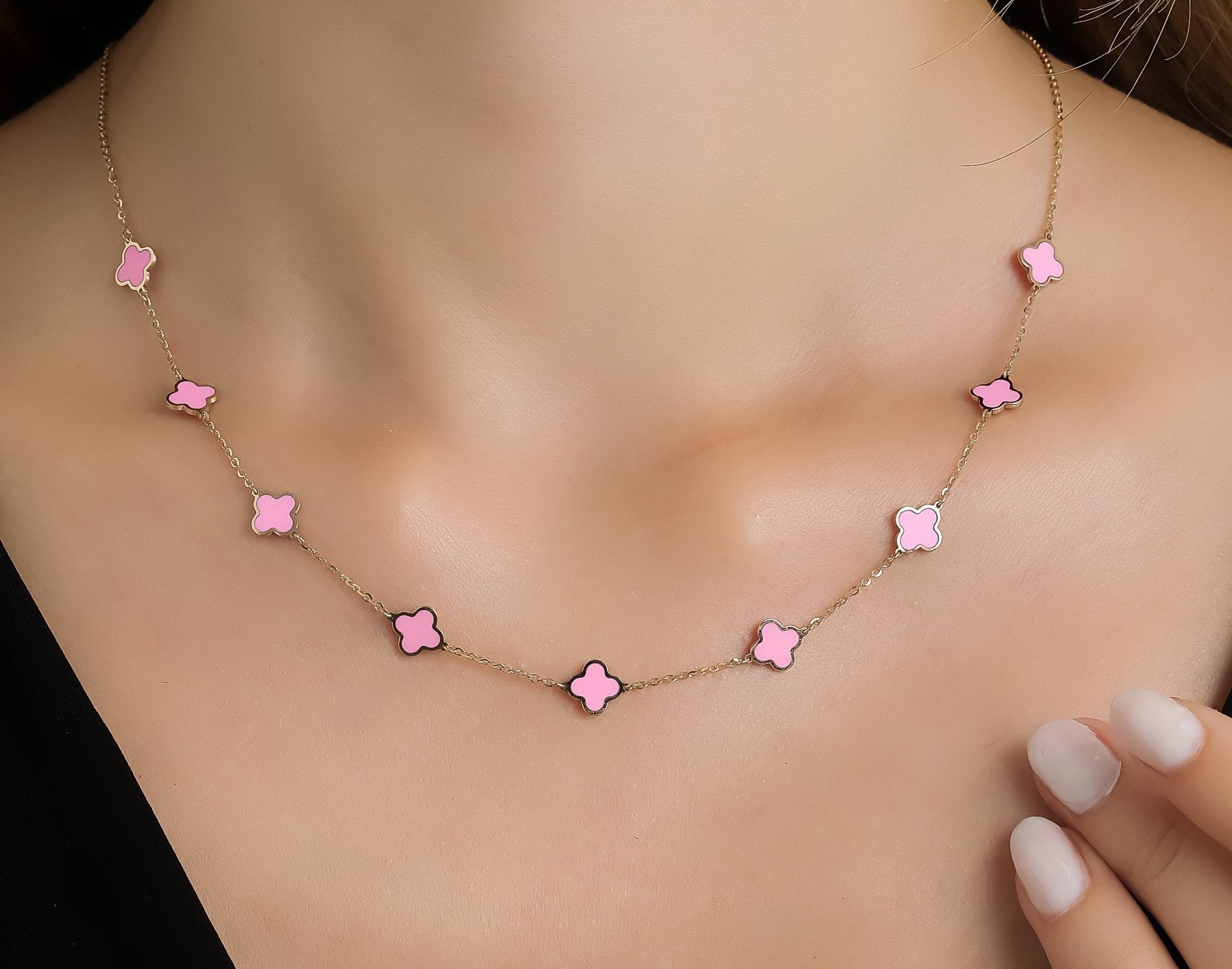 14K solid yellow gold necklace featuring pink four leaf clovers, perfect for any occasion, elegantly worn by a model.