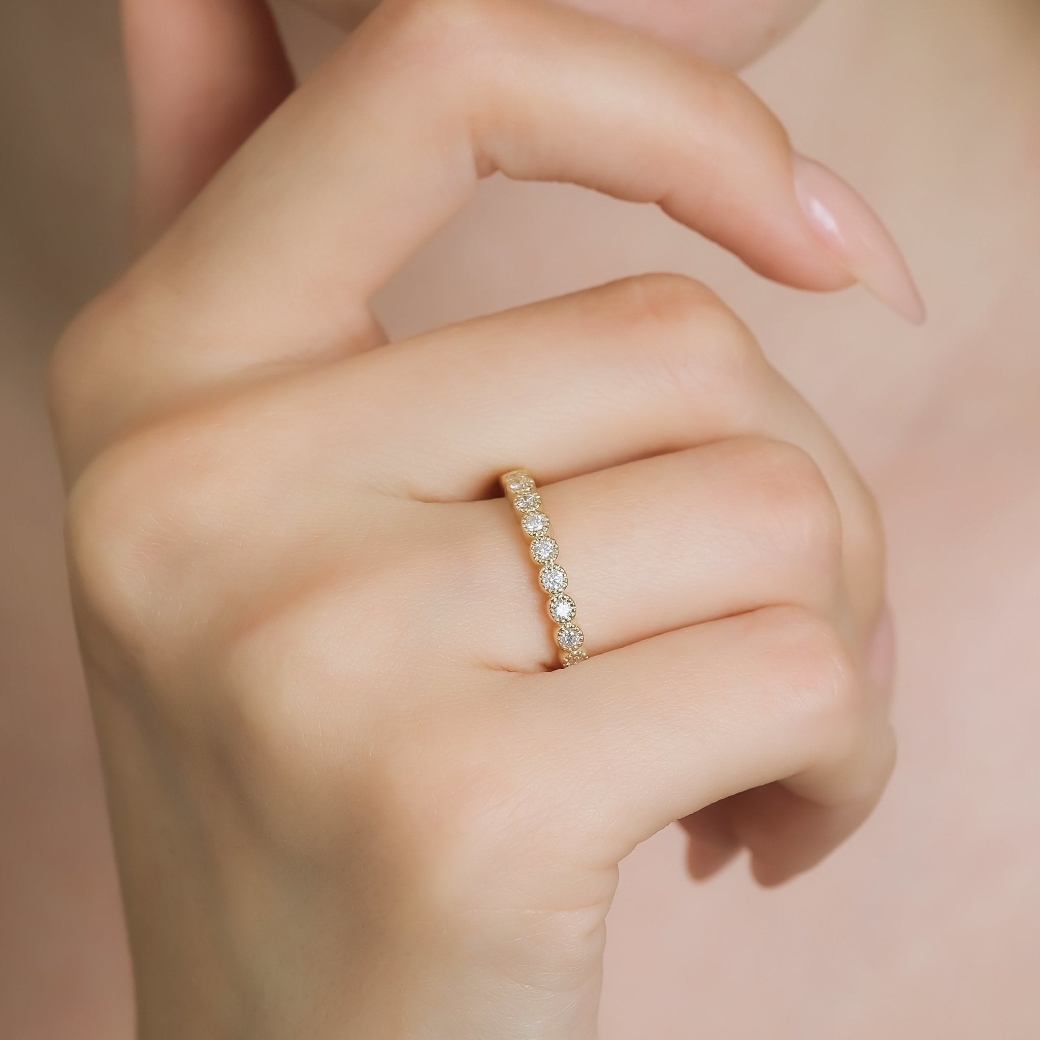 14K yellow gold half eternity diamond wedding ring with round diamonds, showcased on a woman's finger.