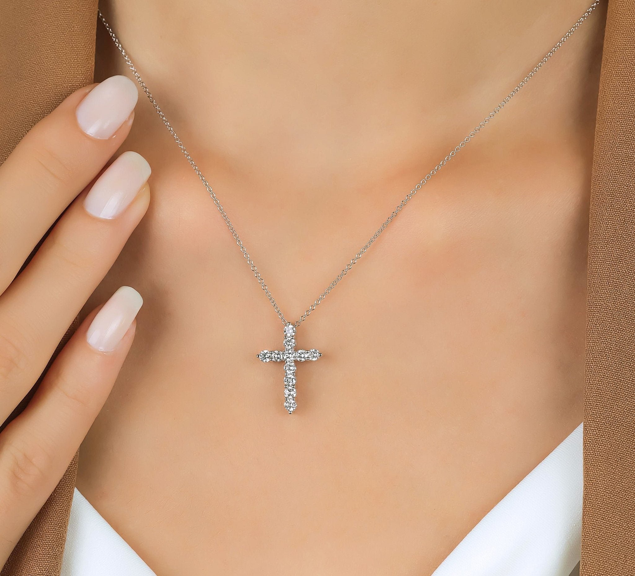 14K white gold cross necklace with lab created diamonds, displayed on a model's neckline.