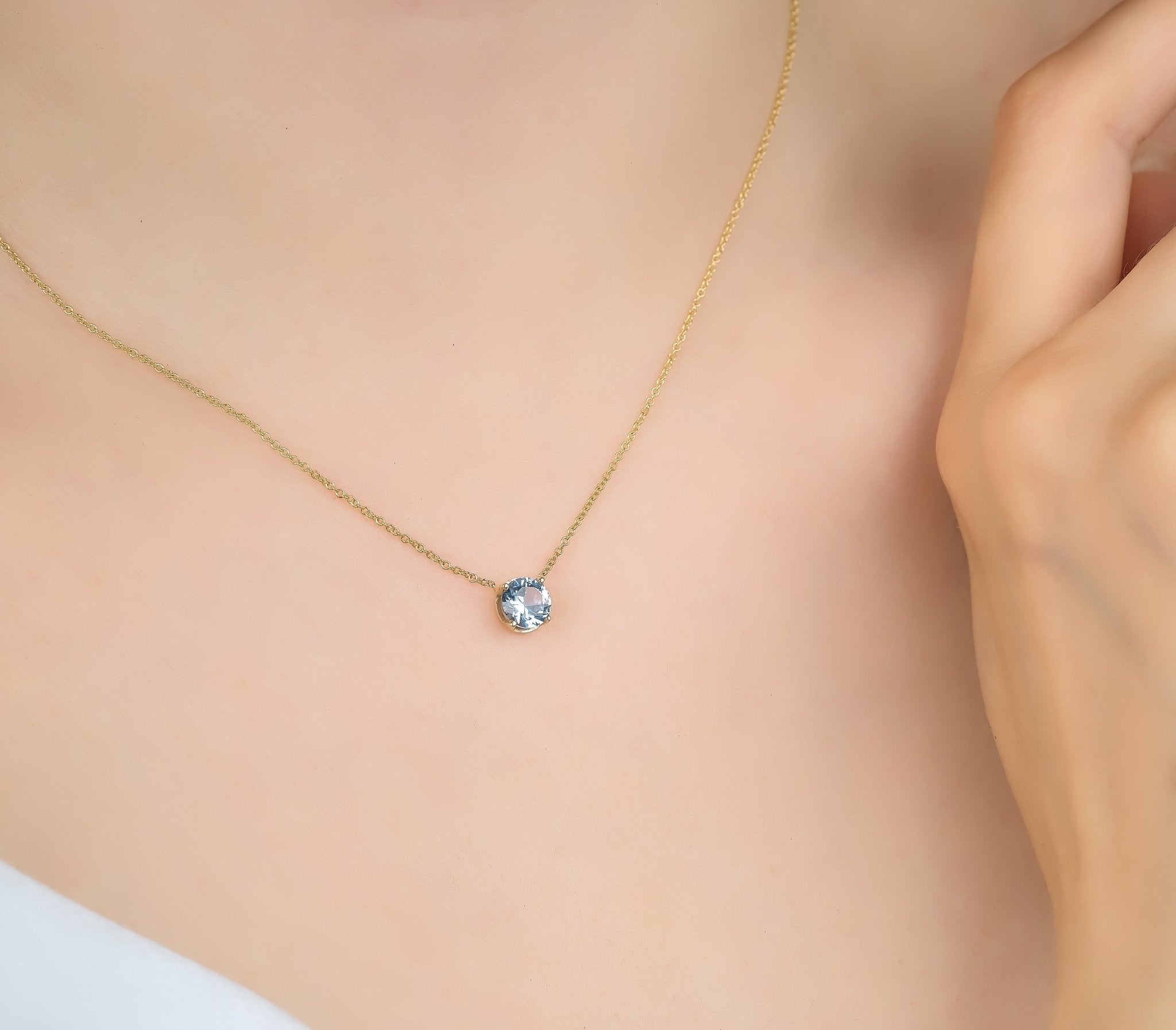 14K white gold 6mm aquamarine solitaire necklace worn elegantly, showcasing its simplicity and minimalist design.