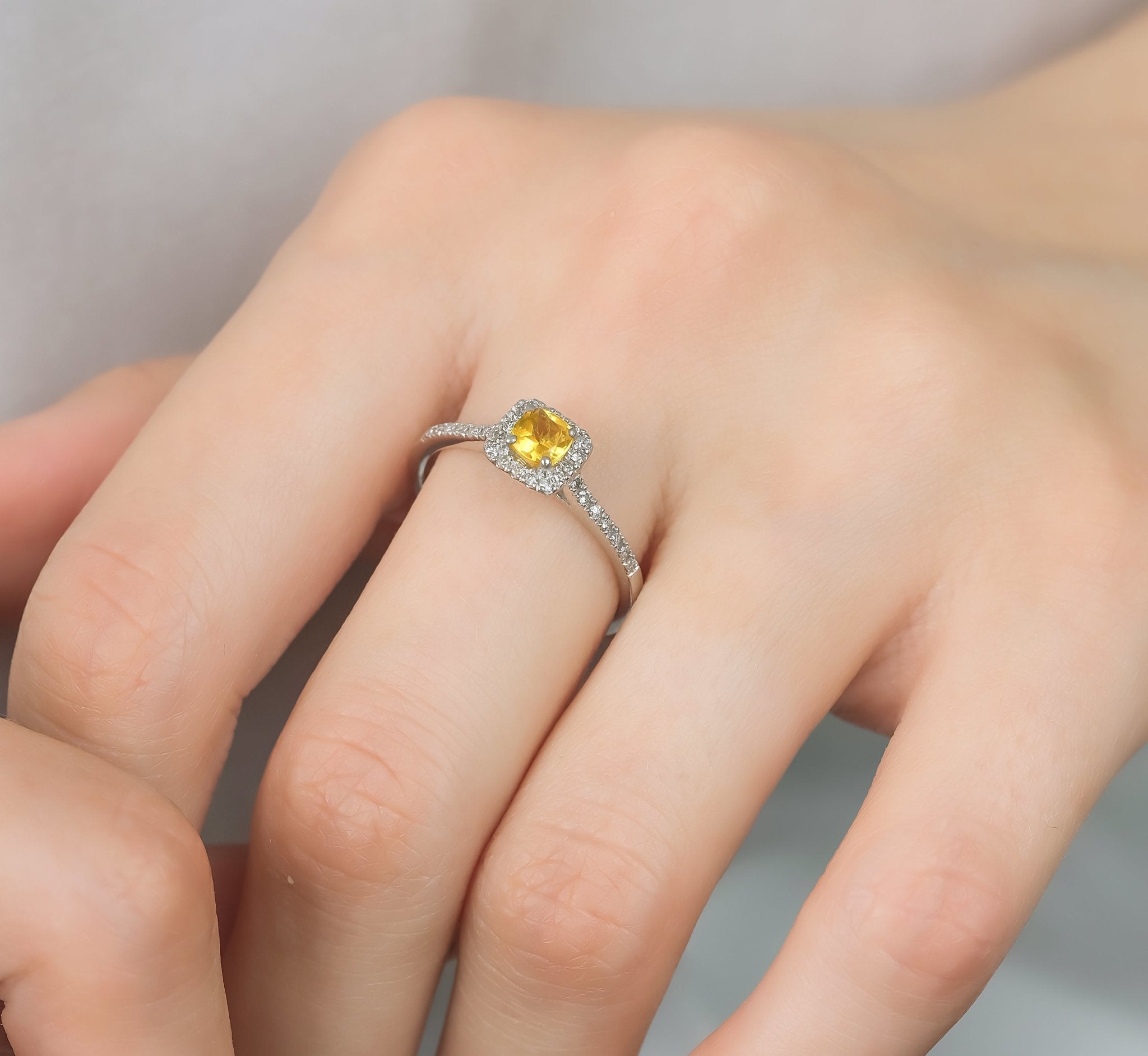 14K white gold cushion cut citrine and diamond ring displayed on a hand, featuring a sparkling 0.25 carat citrine center stone.