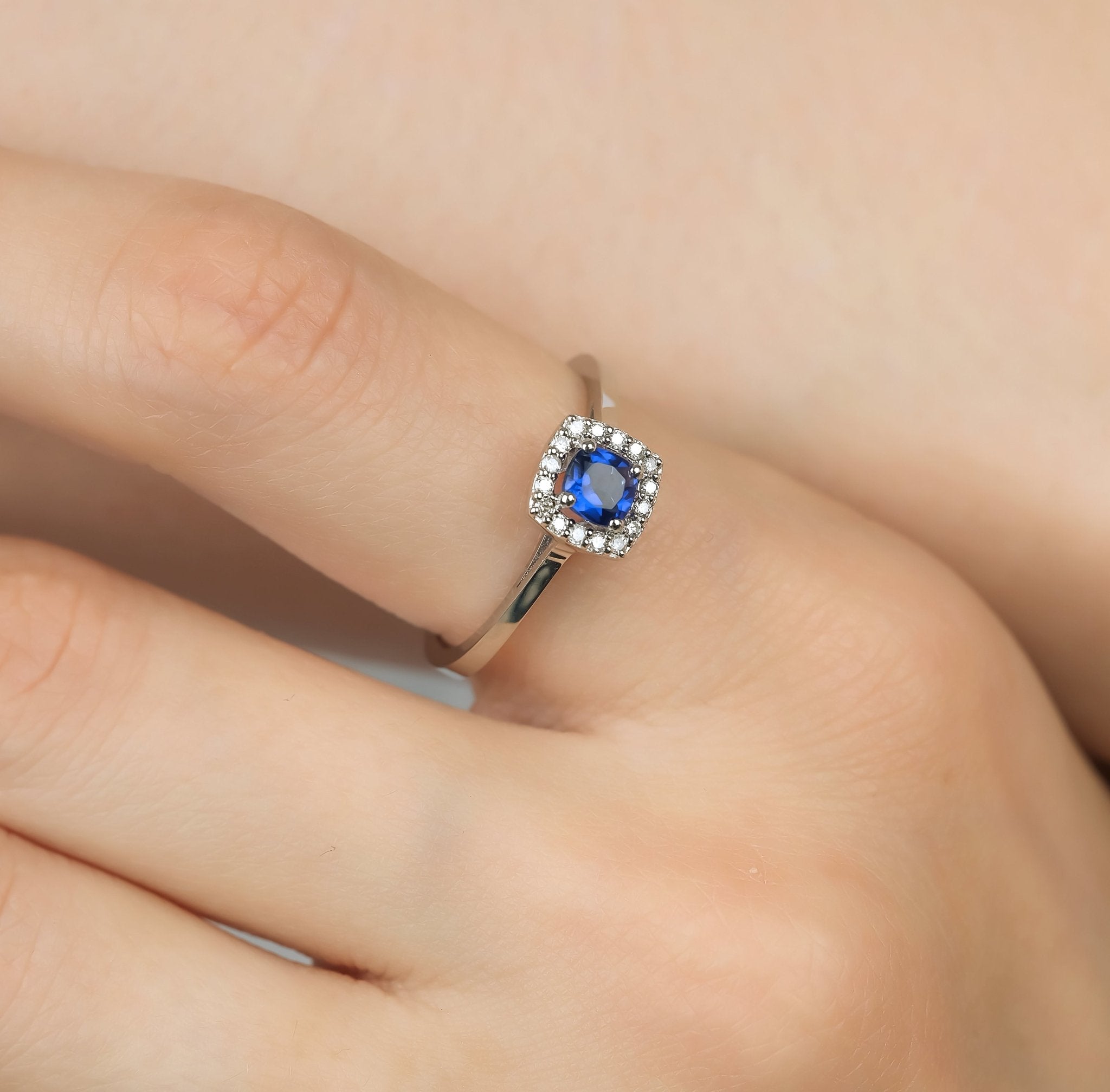 14K white gold cushion cut sapphire and diamond ring displayed on a finger, highlighting the exquisite design and craftsmanship.