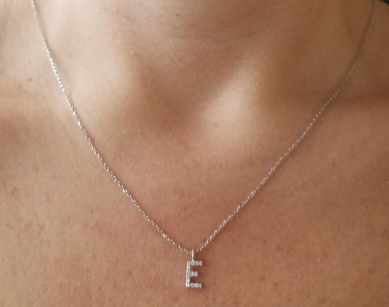 14K white gold diamond initial necklace with letter E, elegantly displayed on a model's neck.