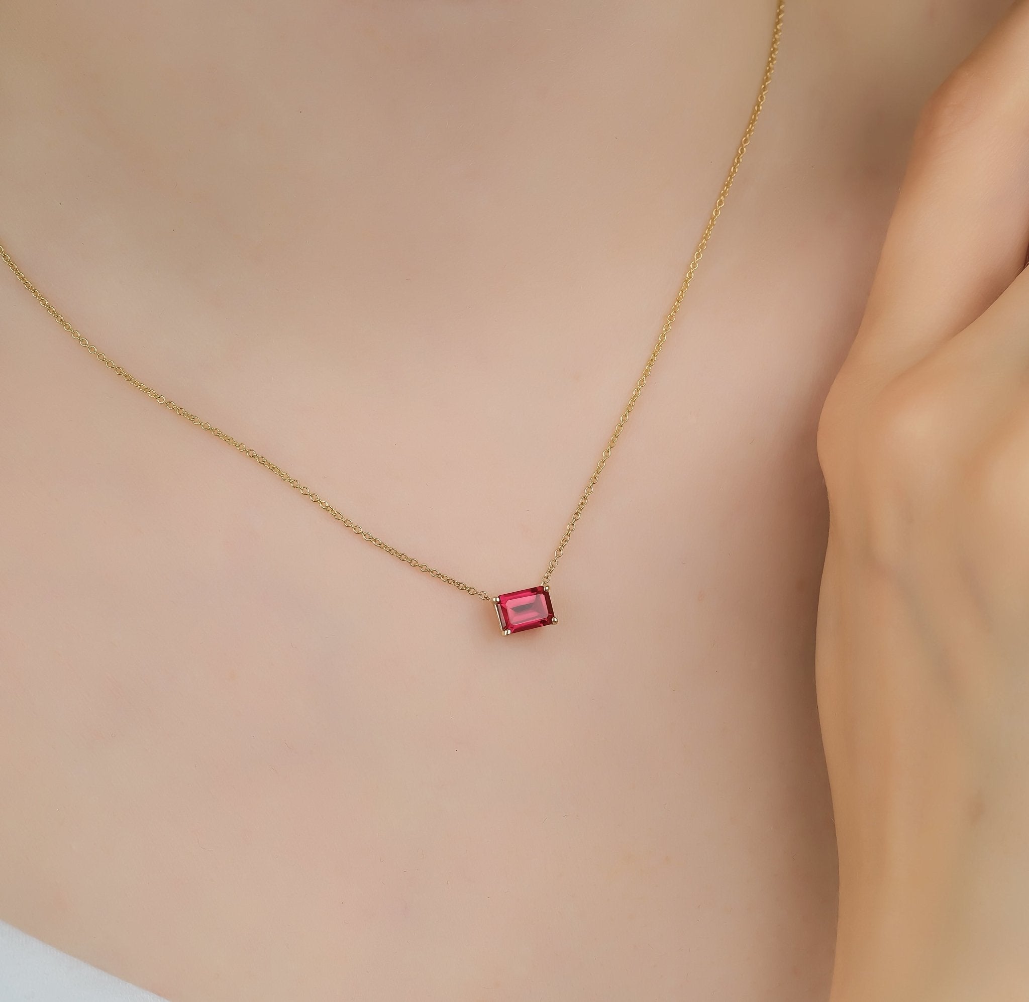14K white gold emerald cut ruby solitaire necklace on model, featuring a 1.00ct lab-created ruby, minimalist style.