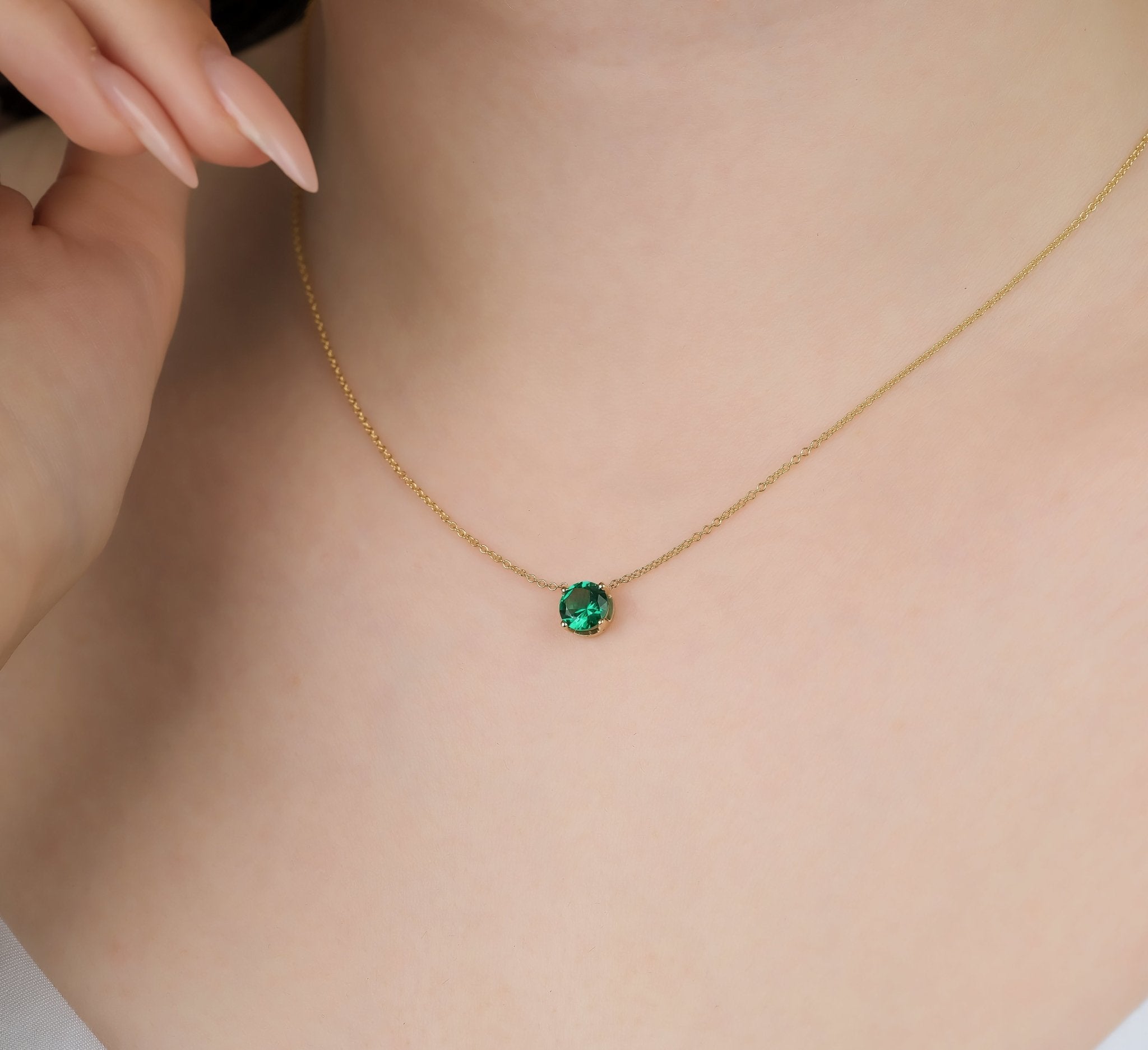 Delicate 14K yellow gold necklace featuring a 6mm prong set emerald solitaire pendant, perfect for everyday elegance.