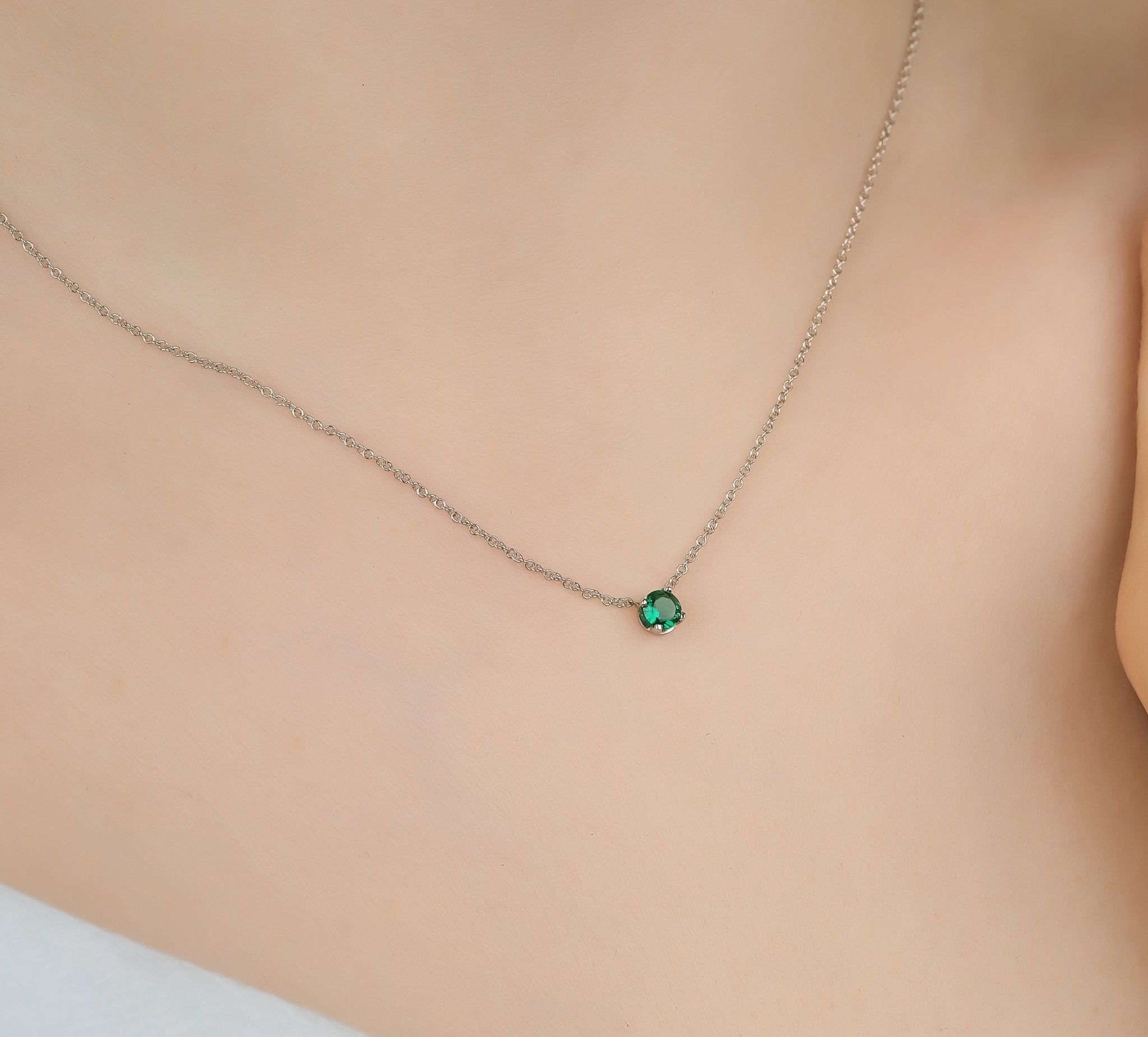 14K white gold prong setting 6mm emerald solitaire necklace displayed on skin, simple and elegant jewelry.