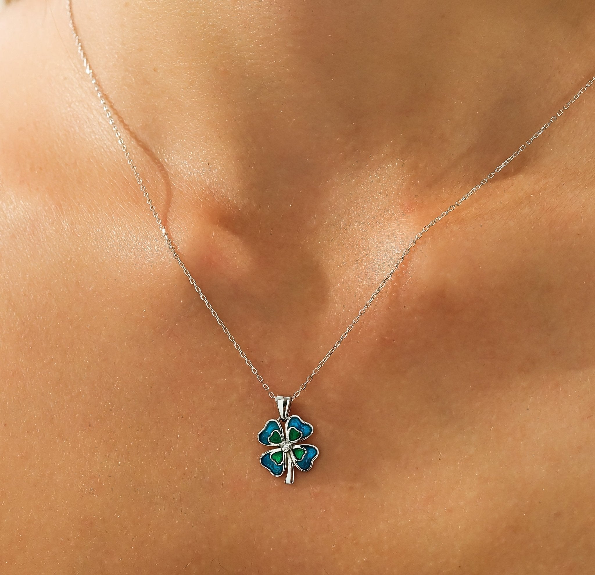 14K solid white gold enamel four leaf clover necklace with diamond, worn on a model's neckline.