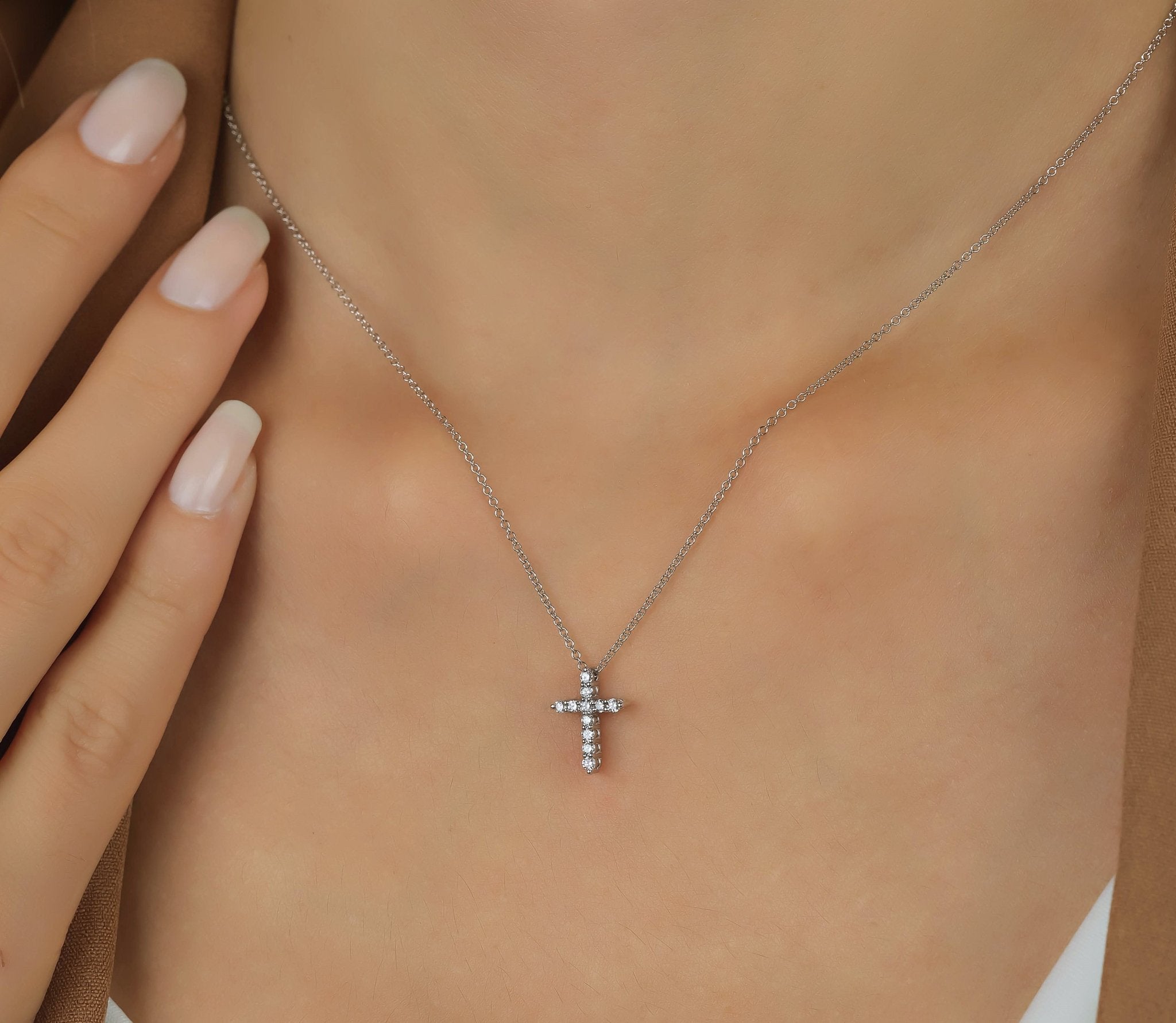 Minimalist diamond cross necklace in 14K white gold worn on a model's neck, showcasing elegance and sparkle.