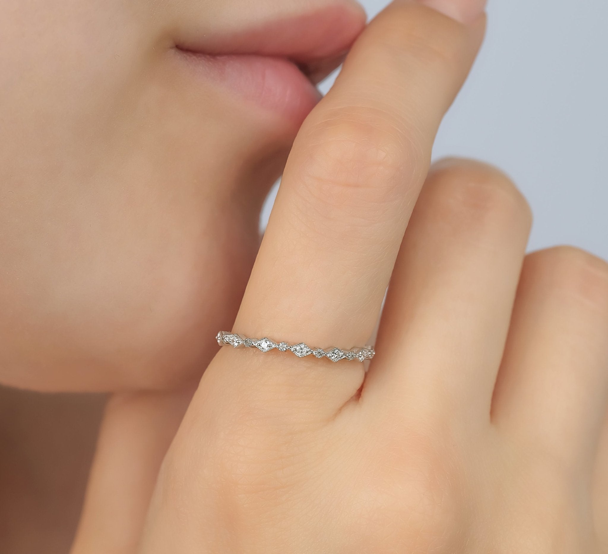 Model wearing a 14K white gold minimalist diamond ring with 13 round diamonds, showcasing elegant simplicity.