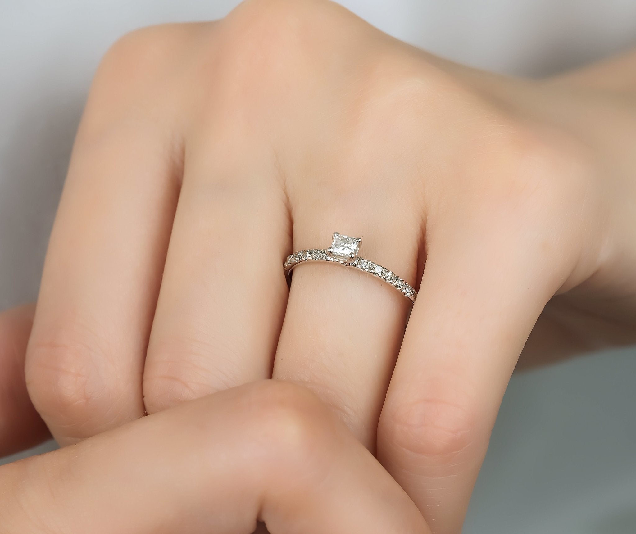 14K white gold emerald cut diamond engagement ring with round diamonds, showcasing elegance and timeless beauty.