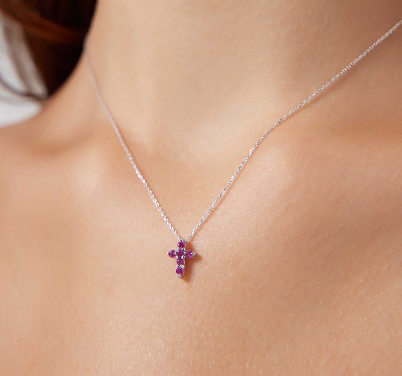 Dainty 14K white gold ruby cross necklace on display, featuring six lab-created rubies and minimalist design, perfect for everyday wear.