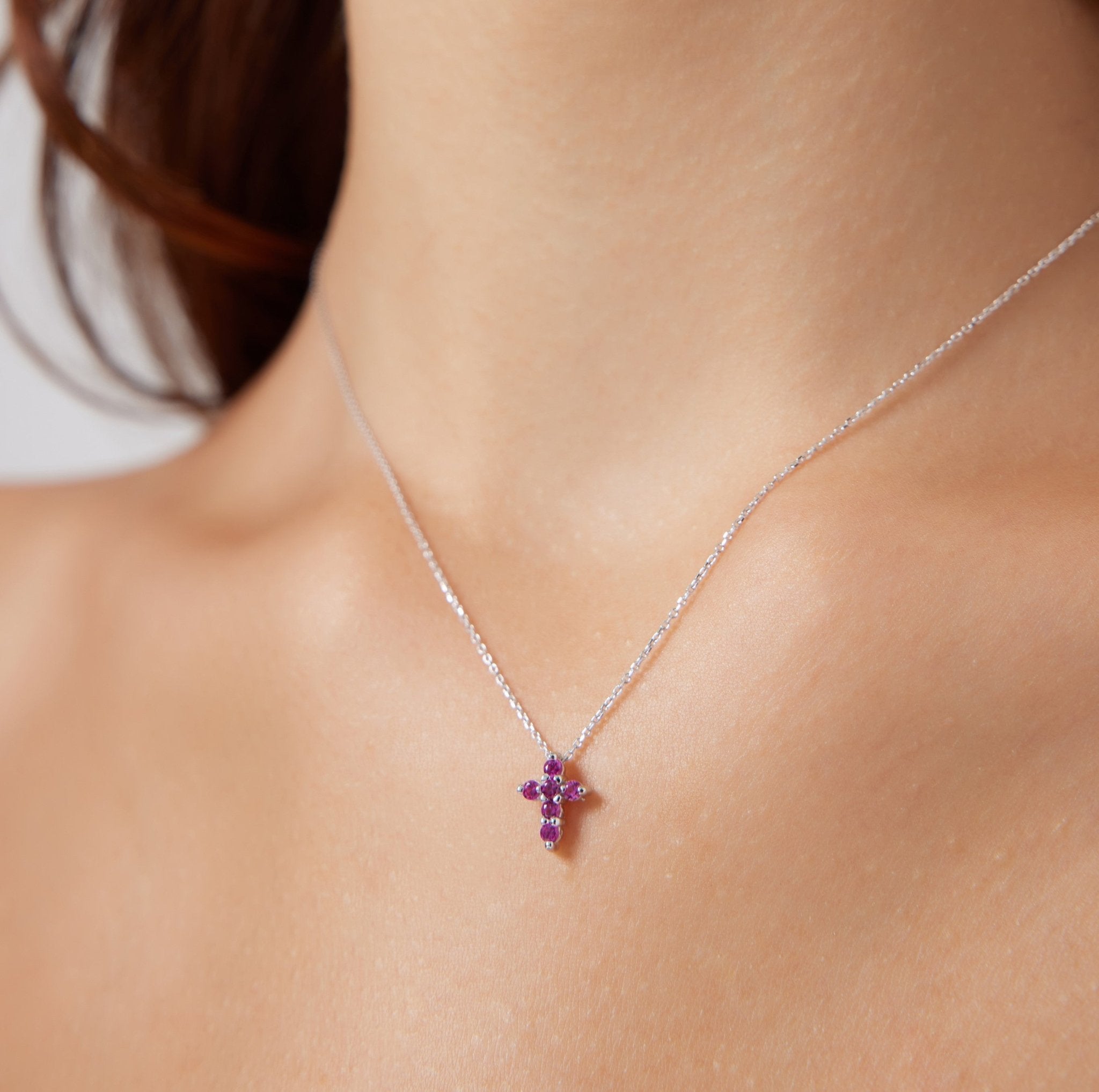 14K white gold minimalist ruby cross necklace worn on neck, featuring six lab-created ruby stones for a dainty and elegant look.