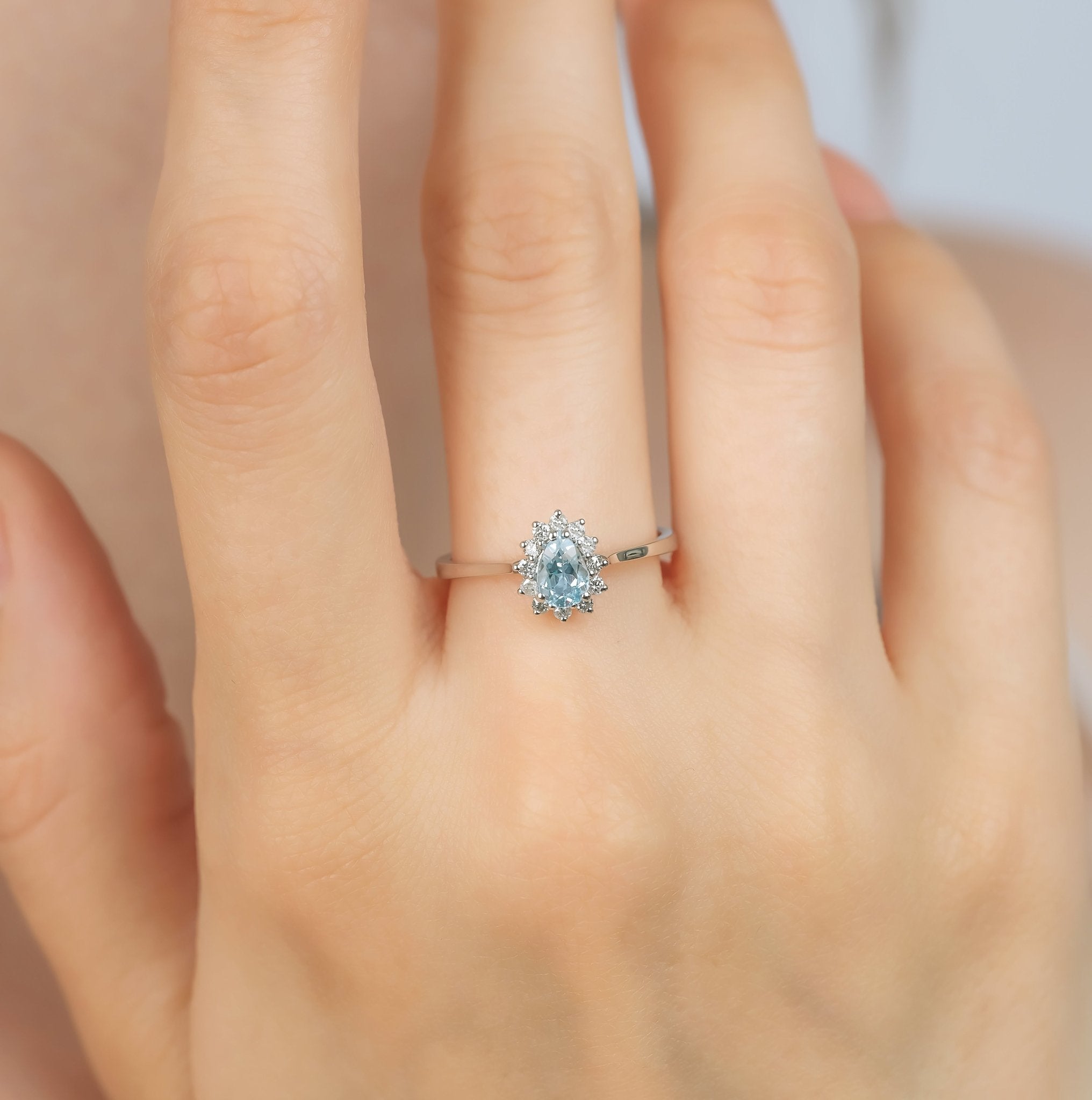14K white gold women's pear shape aquamarine and diamond ring on a hand, featuring a 0.45 carat aquamarine center stone.