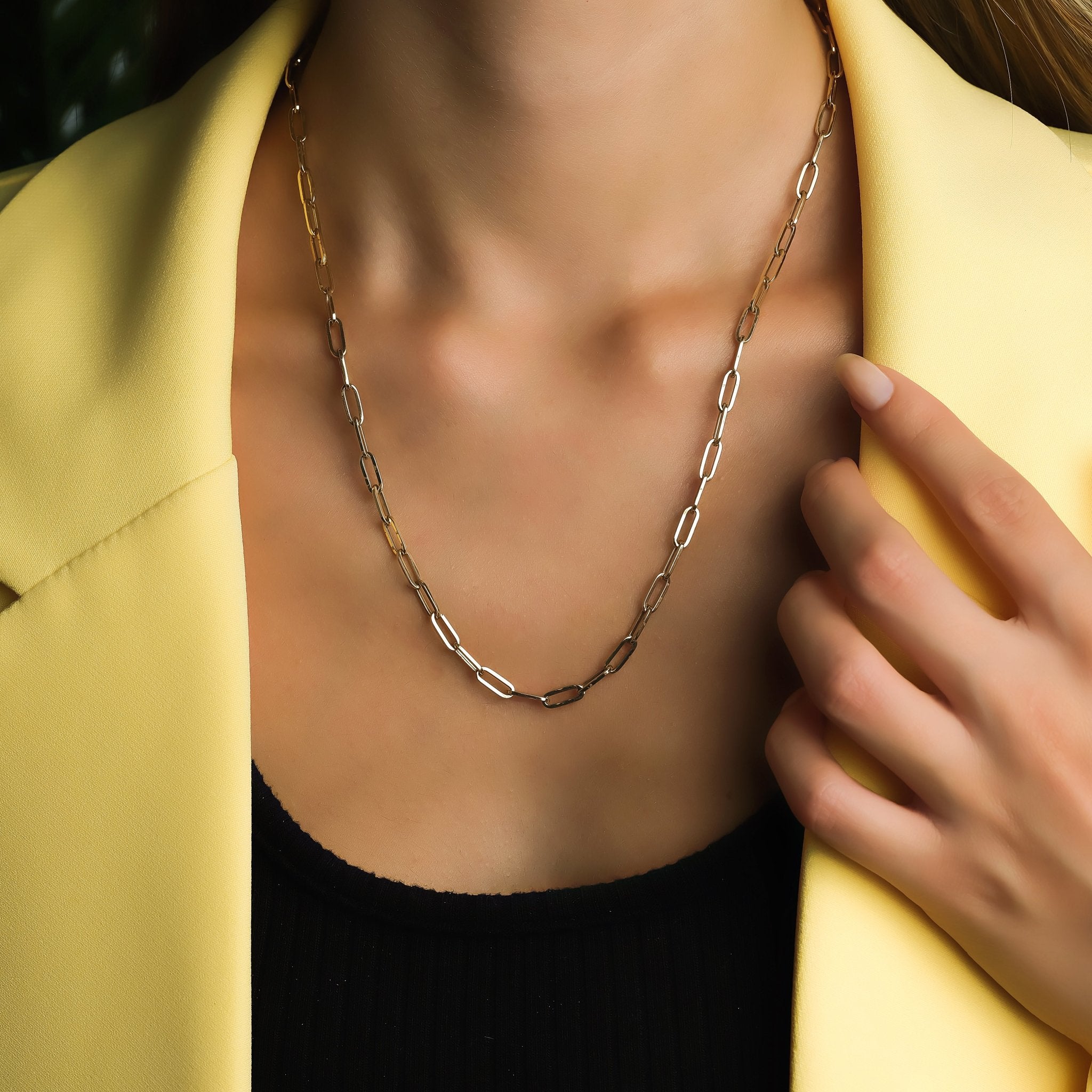 14K yellow gold paperclip necklace worn by model, showcasing delicate links against a stylish outfit.