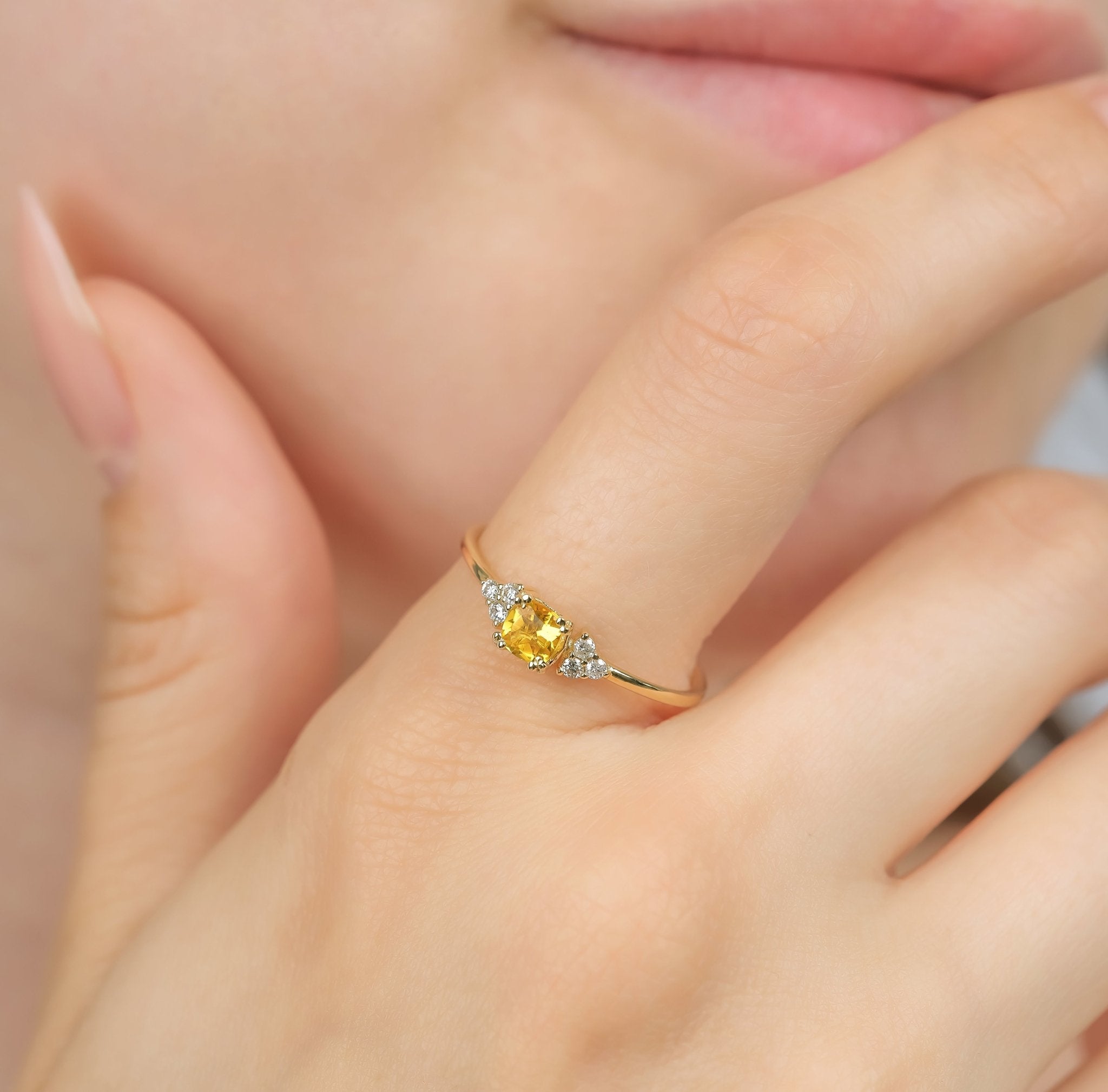 14K yellow gold cushion cut citrine and diamond ring worn on hand, featuring a 0.40 carat citrine and six round diamonds.