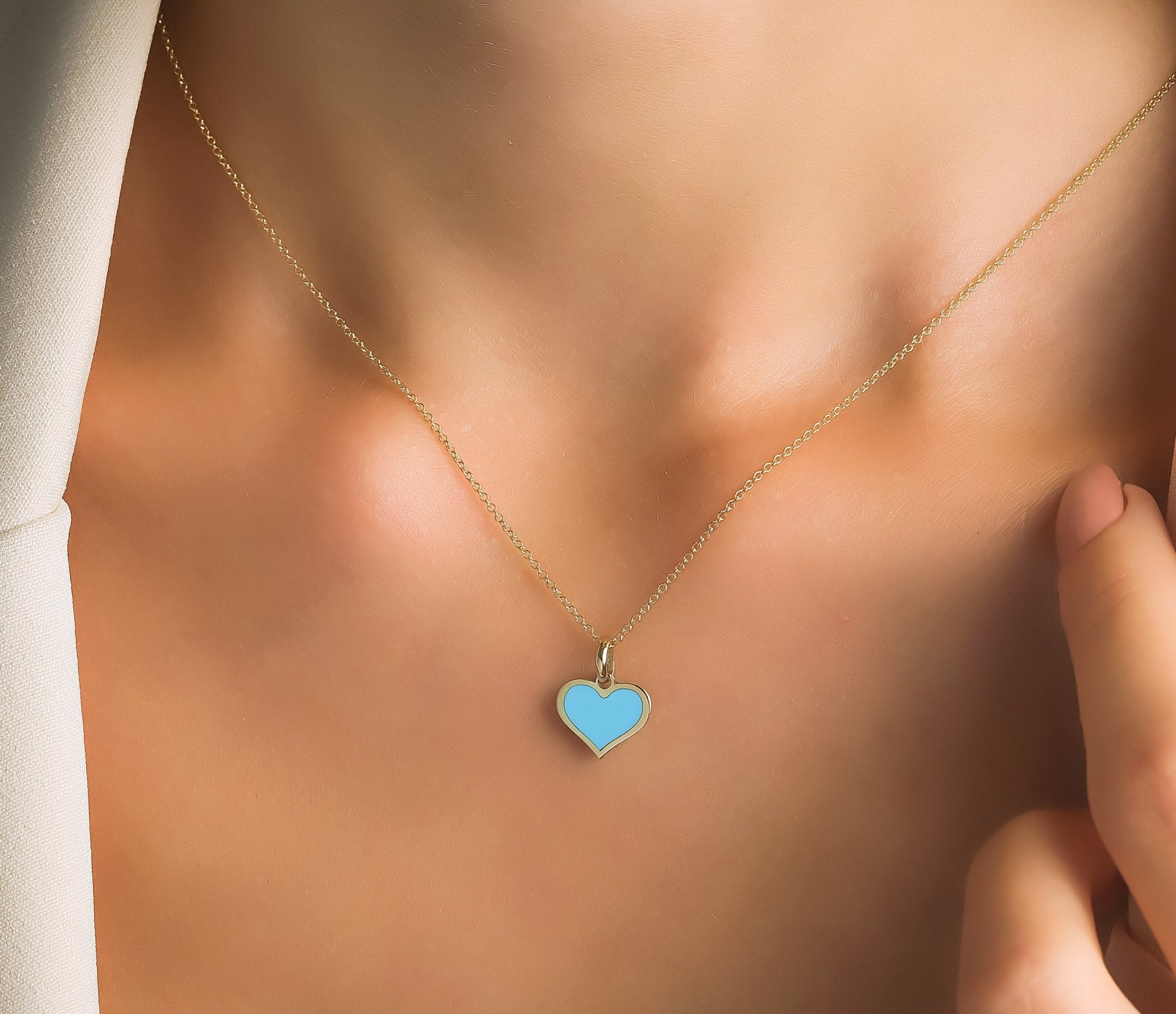 14K yellow gold minimalist turquoise heart necklace worn on a model's neck, elegant and dainty for everyday use.