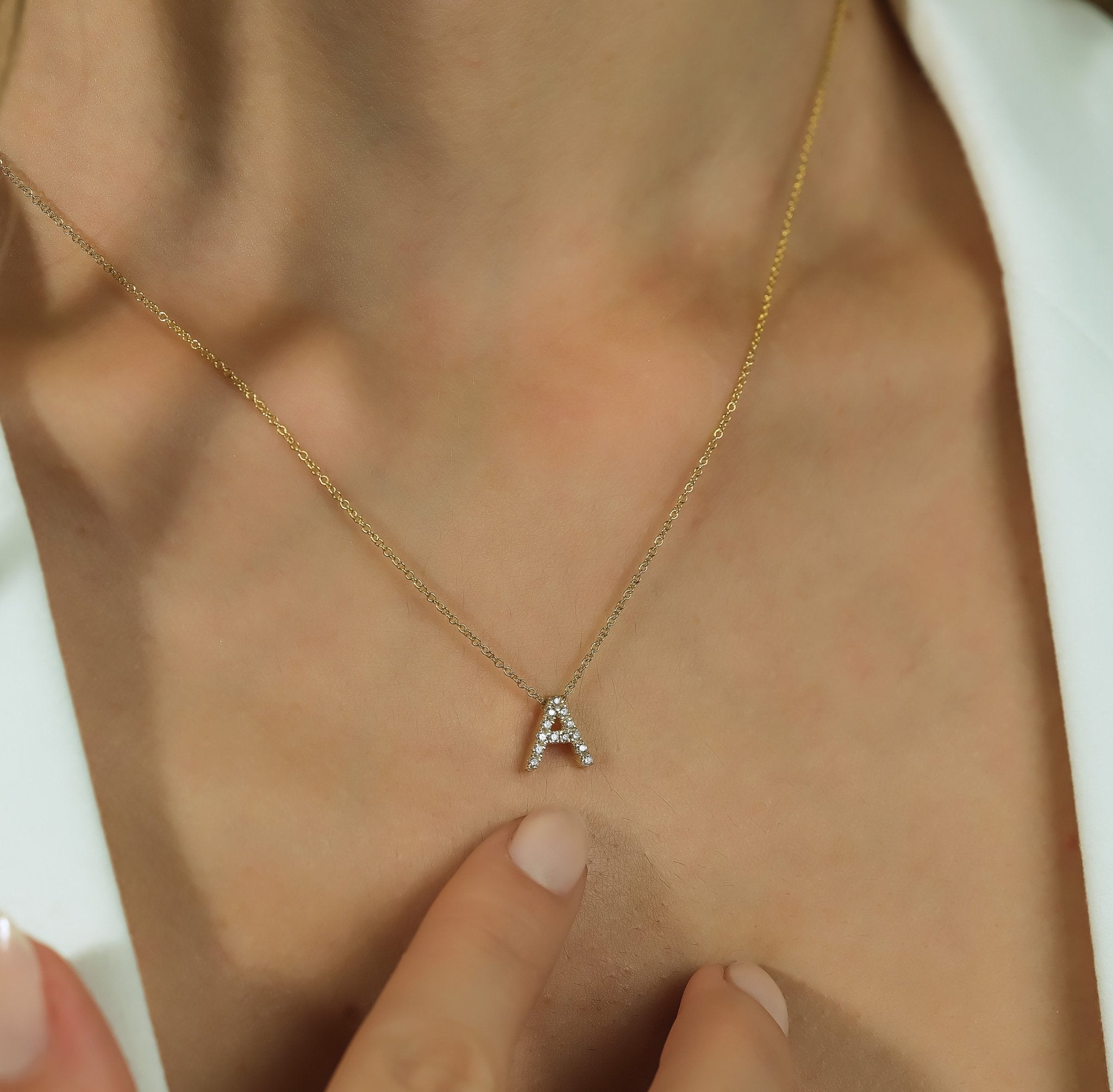 14K yellow gold necklace featuring an elegant diamond initial 'A', model showcasing its beauty.