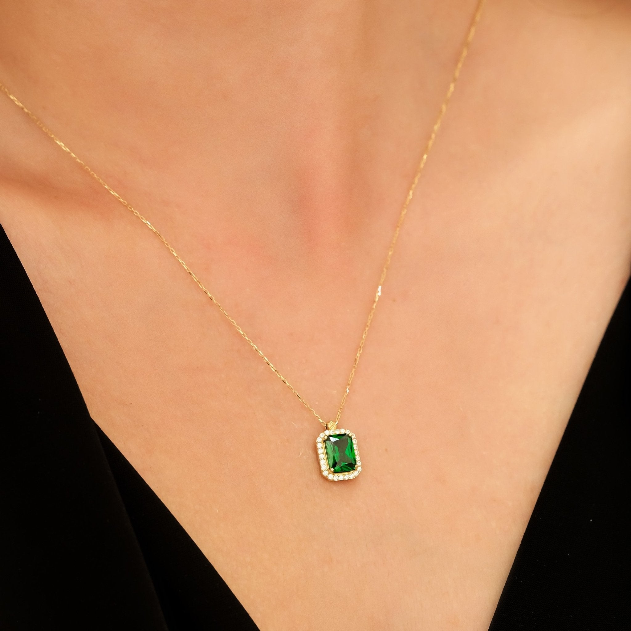 Elegant gold necklace featuring a stunning green gemstone pendant, perfect for adding a touch of sophistication.