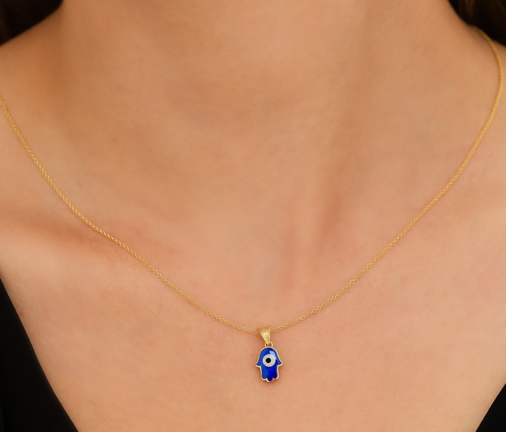 Delicate gold necklace featuring a blue Hamsa pendant, perfect for everyday wear and minimalist style.