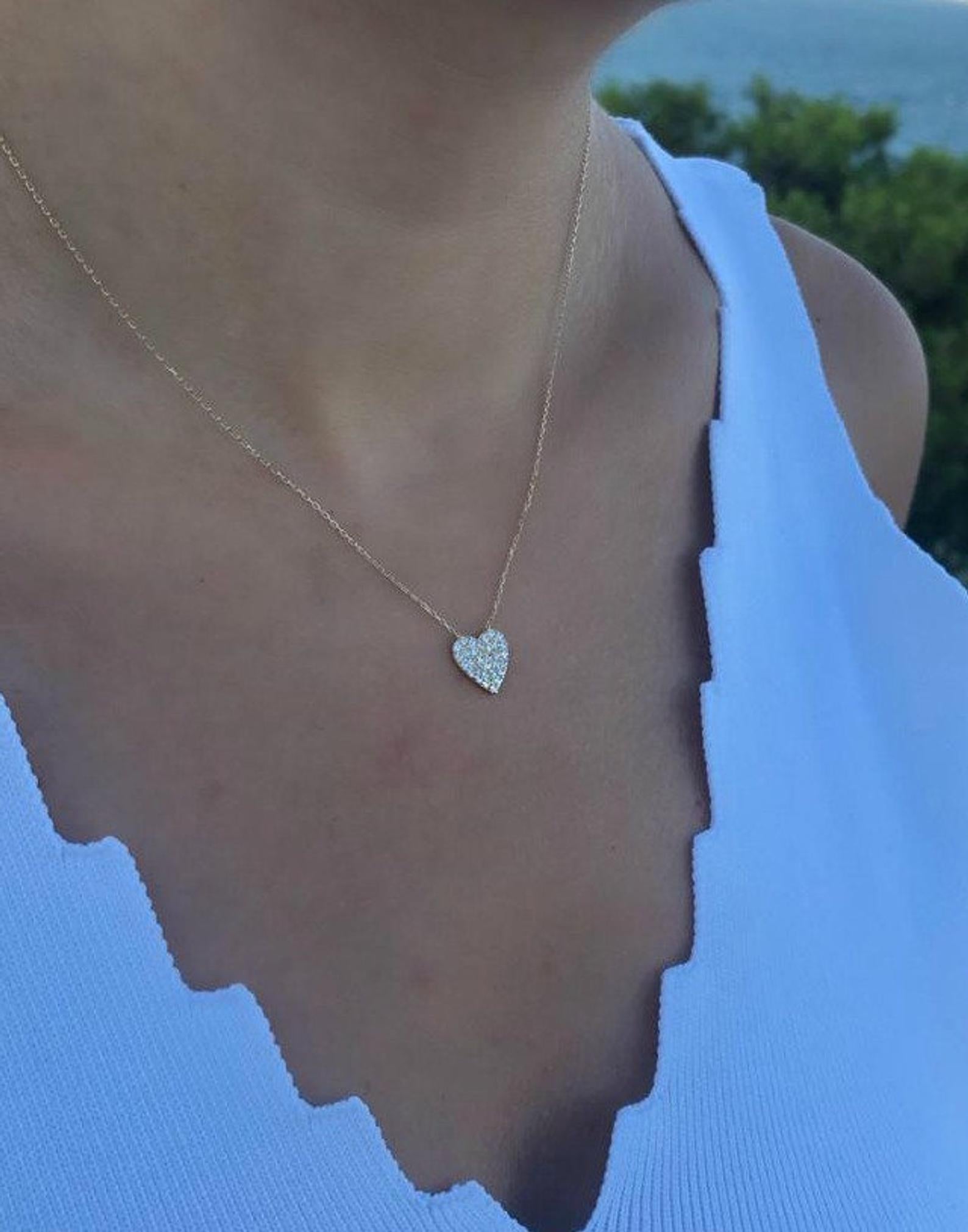 Dainty heart necklace in 14K solid yellow gold with CZ, worn elegantly on a person's neck.