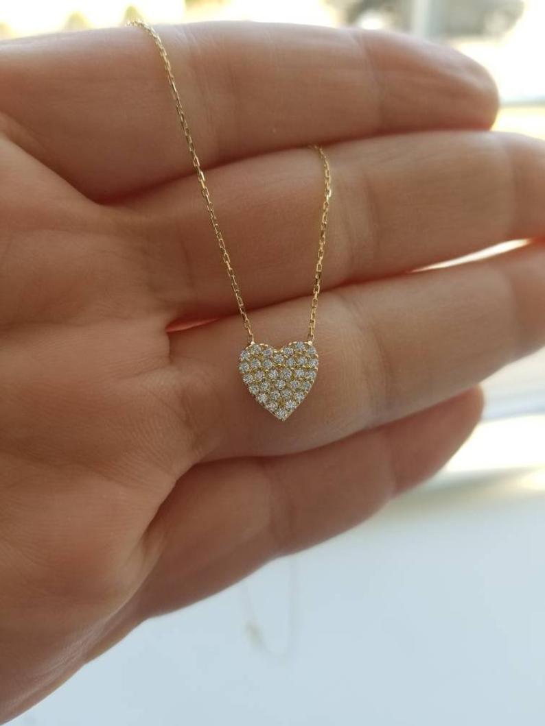 14K solid yellow gold dainty heart necklace with CZ, held in hand, perfect for everyday wear, minimalist jewelry.