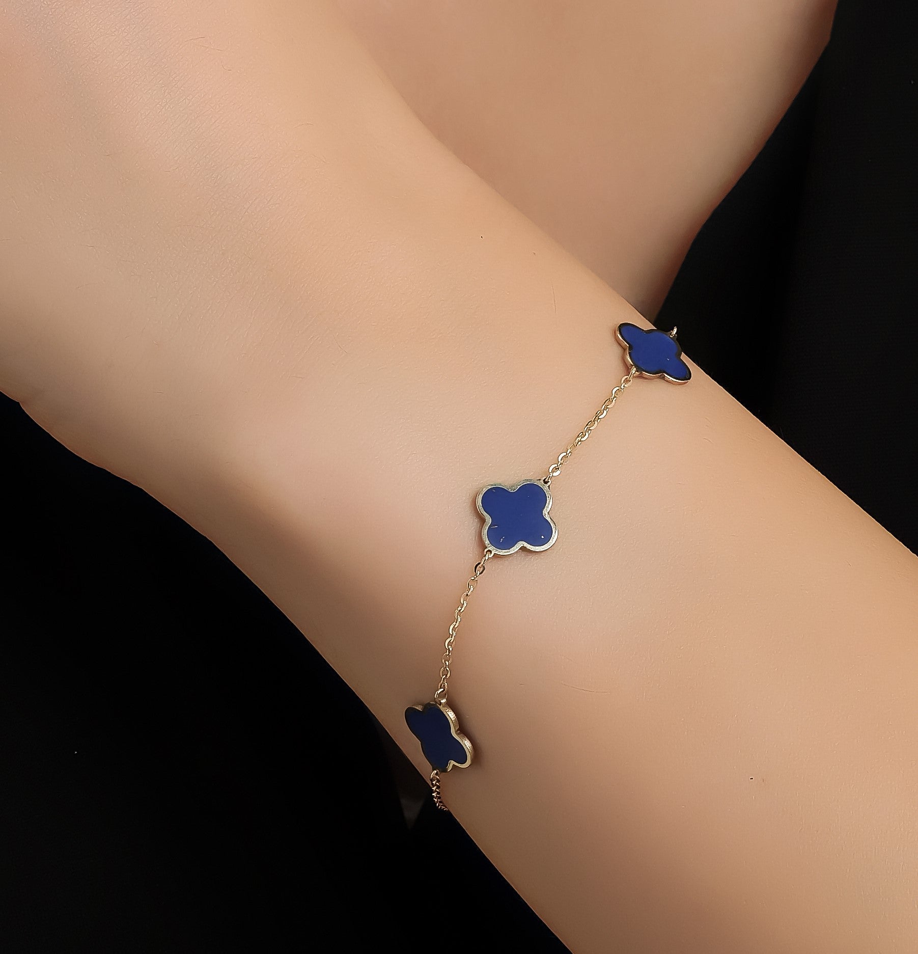 14K yellow gold lapis four leaf clover bracelet worn on wrist, showcasing elegant design and delicate craftsmanship.
