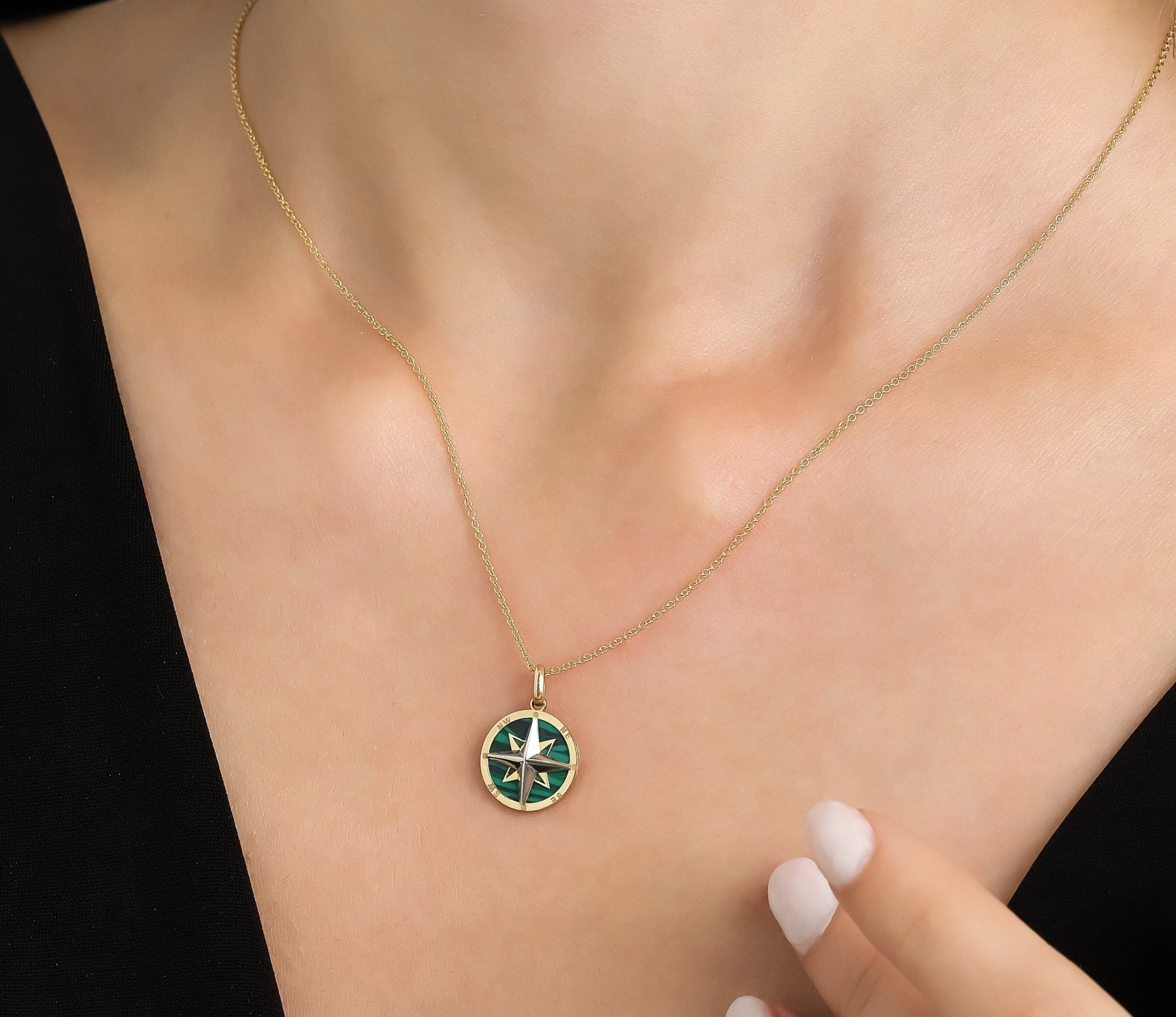 14K yellow gold malachite compass necklace worn on a model's neck, showcasing its elegant design and dainty style.