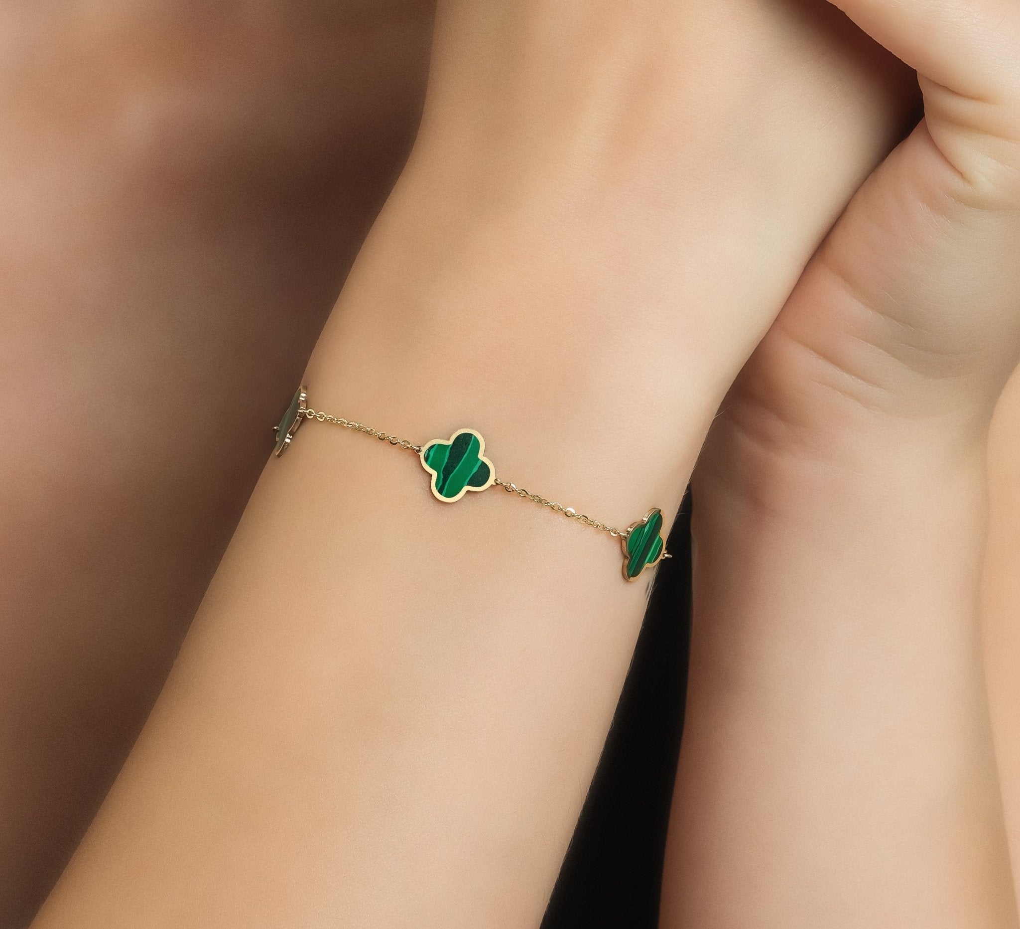 14K solid yellow gold malachite four leaf clover bracelet worn on wrist, showcasing delicate design and vibrant green stones.