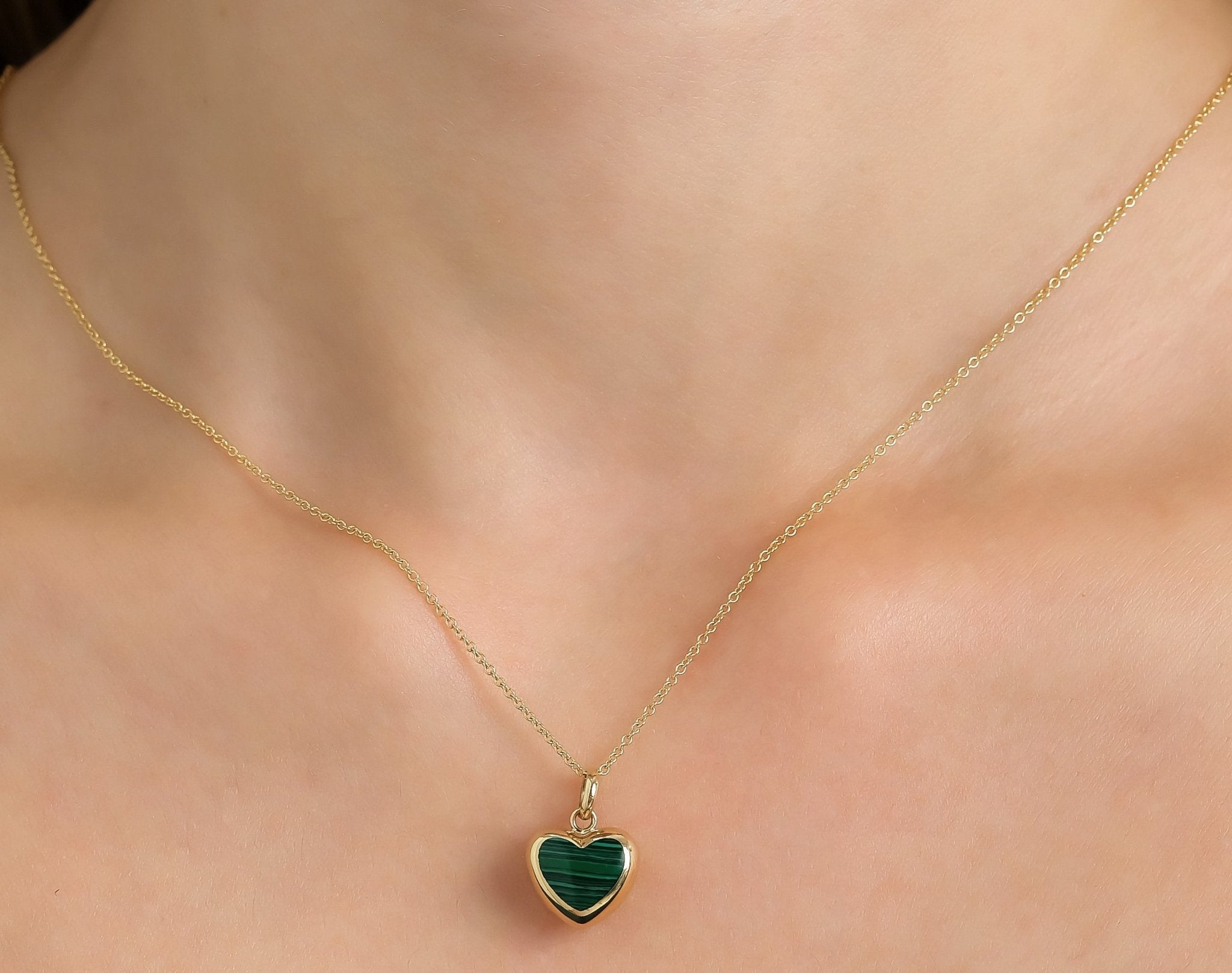 14K yellow gold malachite puffed heart necklace worn on a model, showcasing delicate design and elegance.