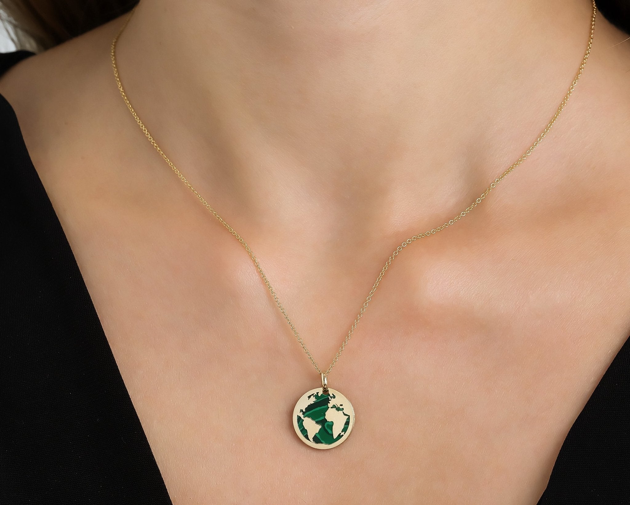 14K yellow gold malachite world map necklace worn on a model, featuring a dainty design perfect for everyday use.