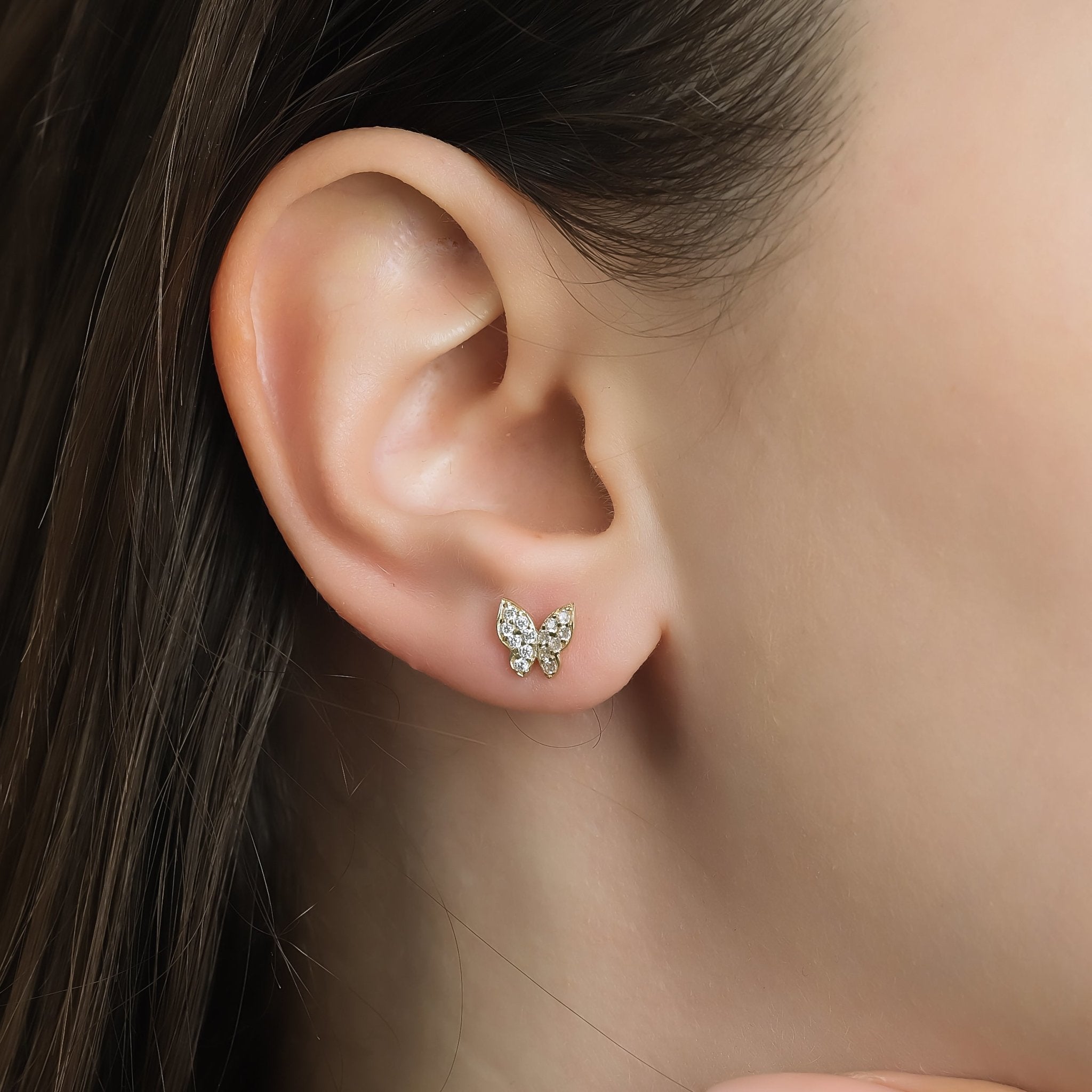 14K yellow gold minimalist butterfly earrings with CZ, displayed on a model's ear for everyday elegance.