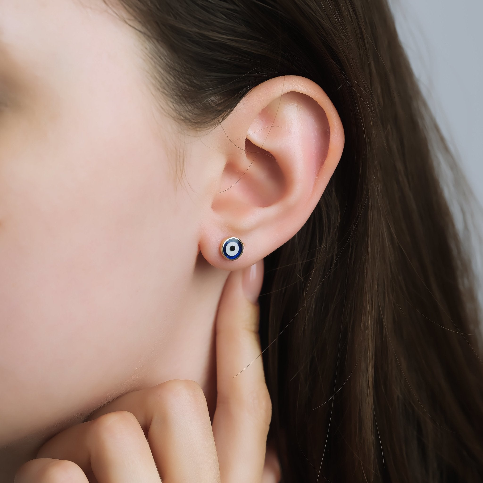 Model wearing 14K Yellow Gold Minimalist Round Evil Eye Stud Earrings, showcasing CZ stones, perfect for everyday use.