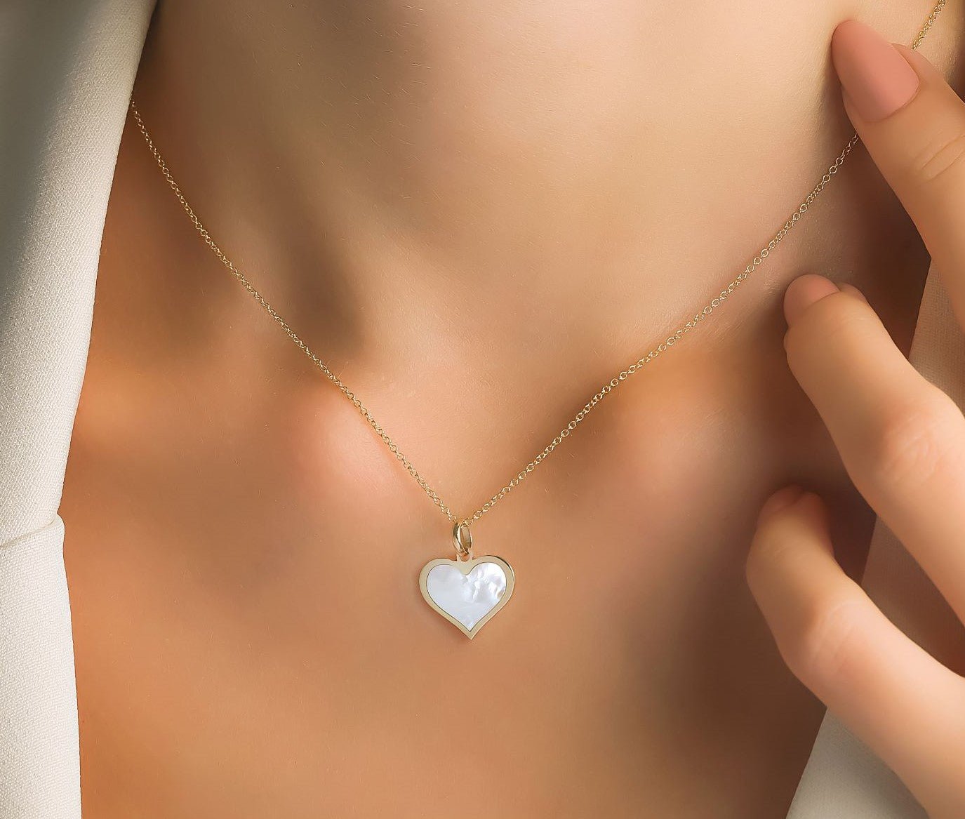 Dainty 14K yellow gold heart necklace with natural pearl pendant, perfect for everyday wear.