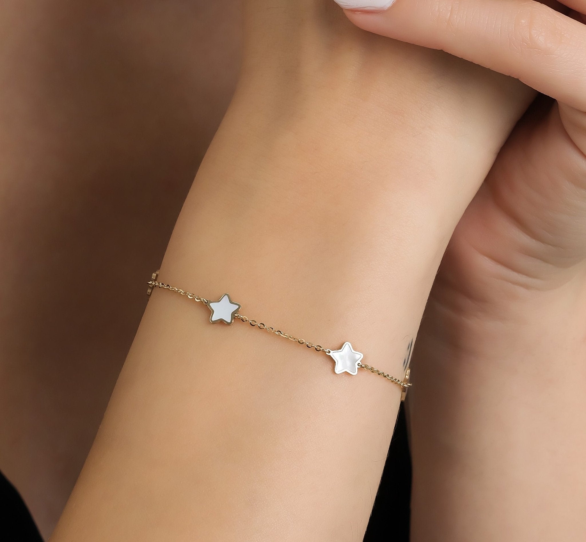 Dainty 14K yellow gold bracelet featuring mother of pearl star stations, elegant for everyday wear.