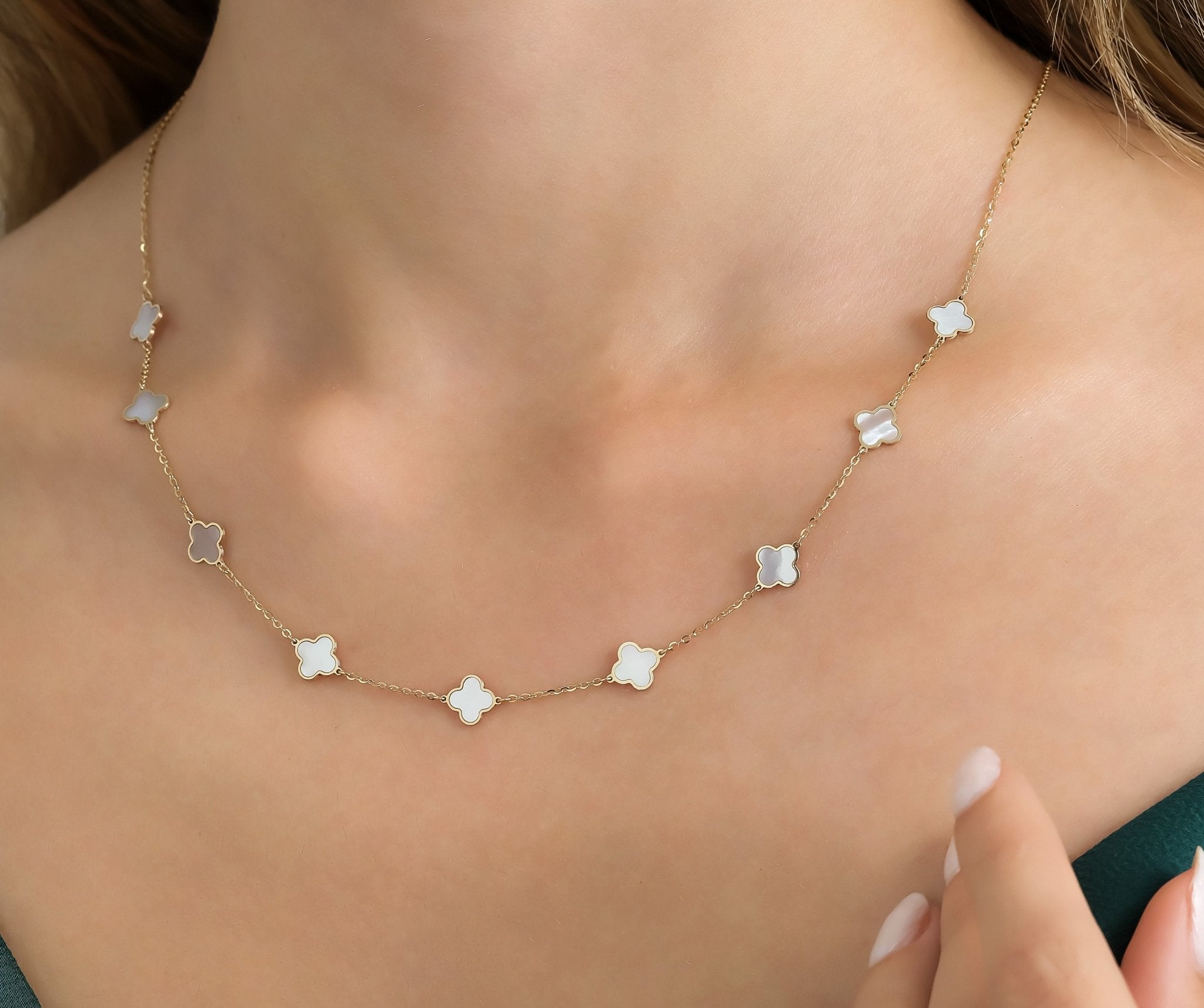 14K yellow gold mother of pearl four leaf clover station necklace worn by a model, featuring a delicate chain.