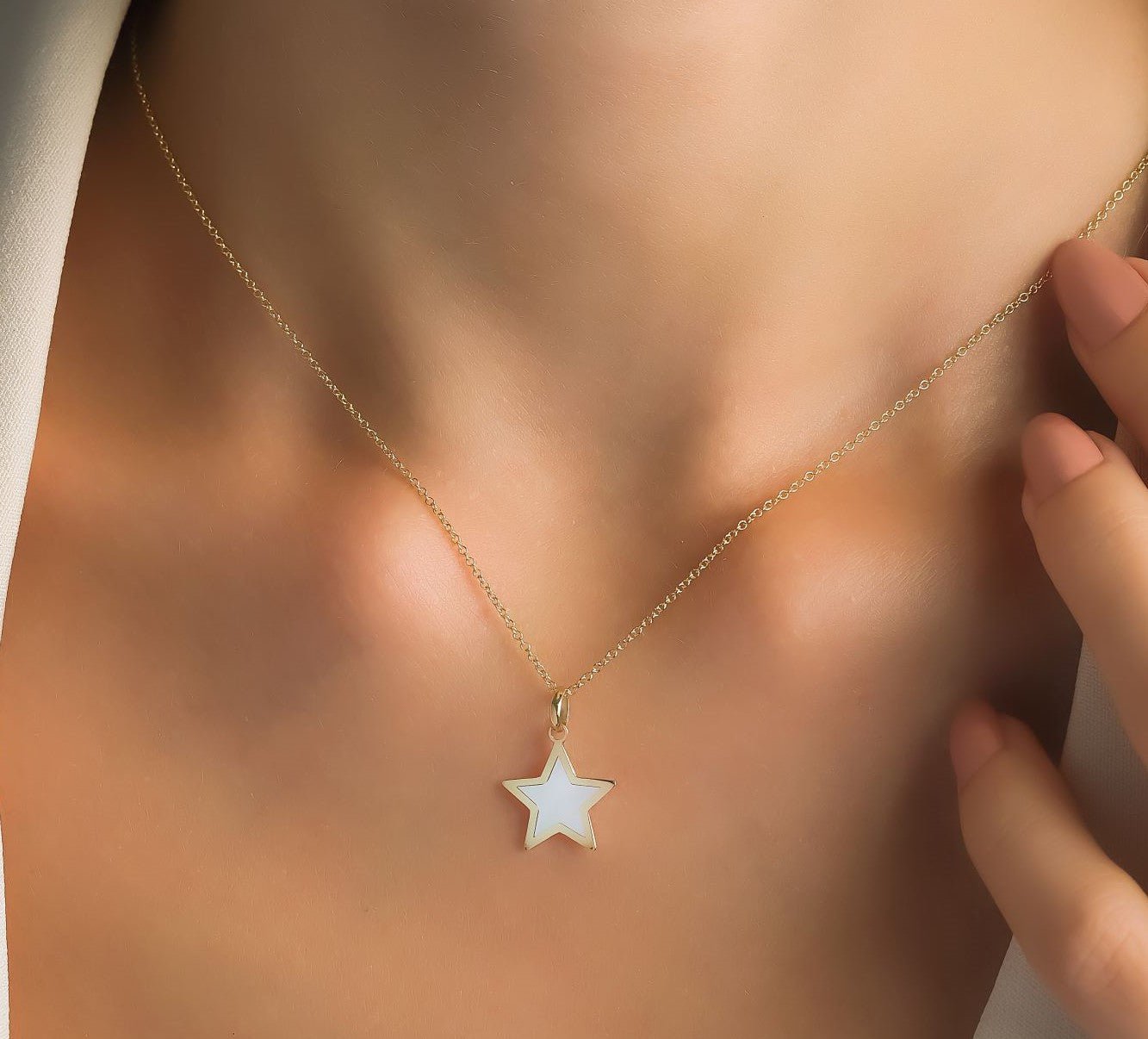 14K yellow gold mother of pearl star necklace elegantly worn, showcasing its dainty design and natural beauty.