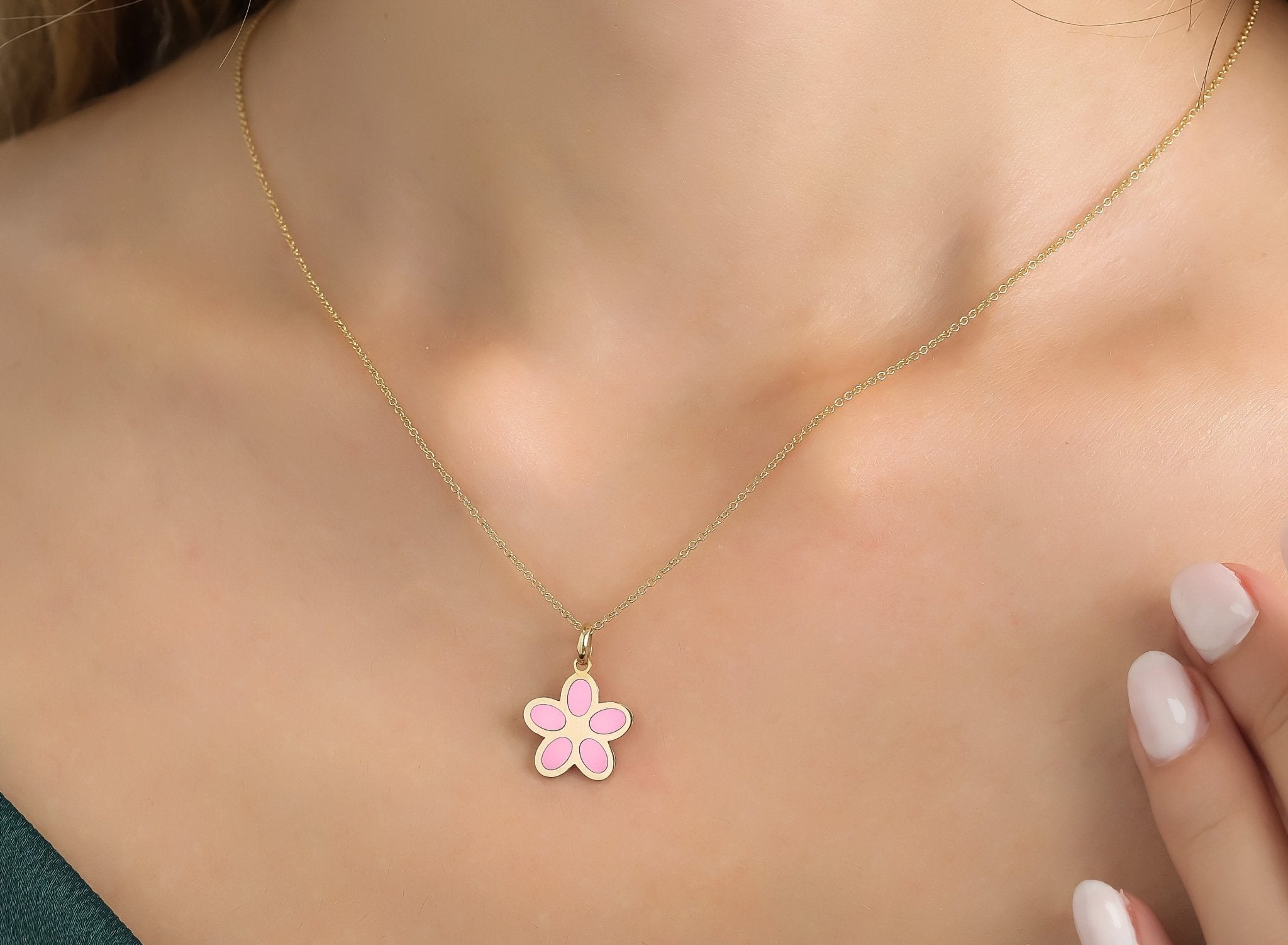 14K yellow gold pink daisy flower necklace worn on a model, showcasing its delicate design and elegant charm.