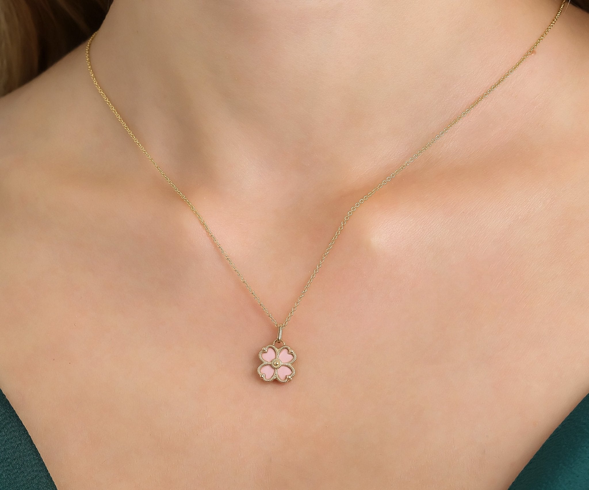 14K yellow gold pink four leaf clover pendant necklace worn on a model, showcasing a delicate and classy design.