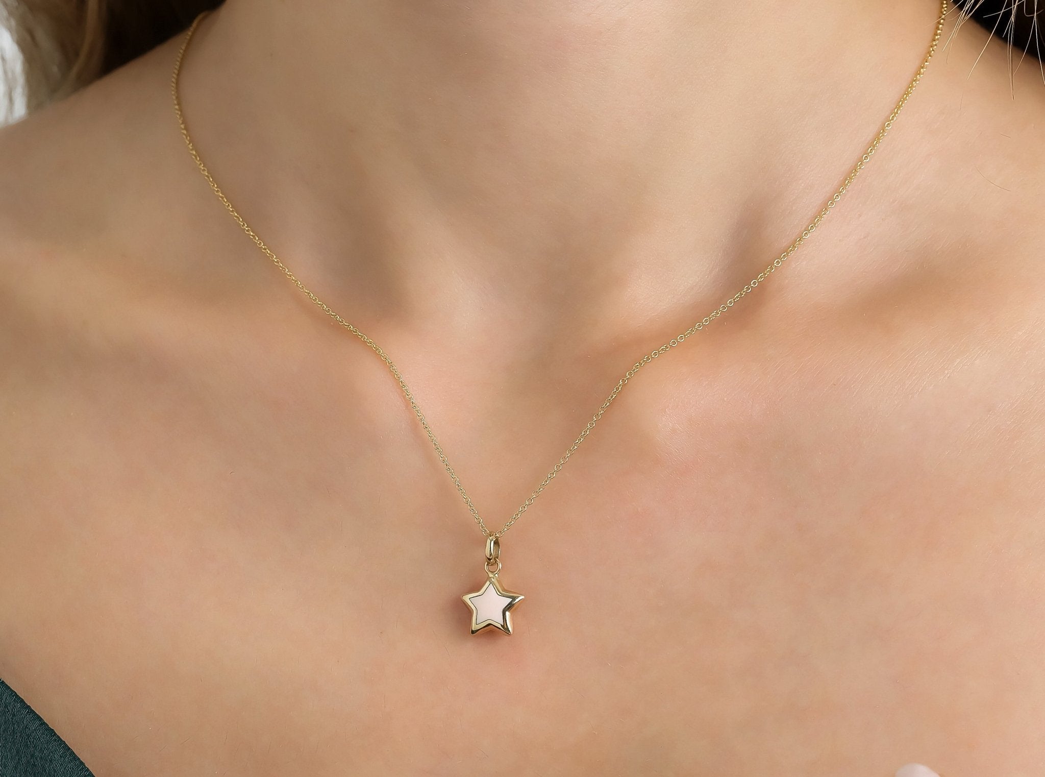 14K yellow gold puffed pink star necklace showcased on a model's neck, highlighting its dainty and elegant design.