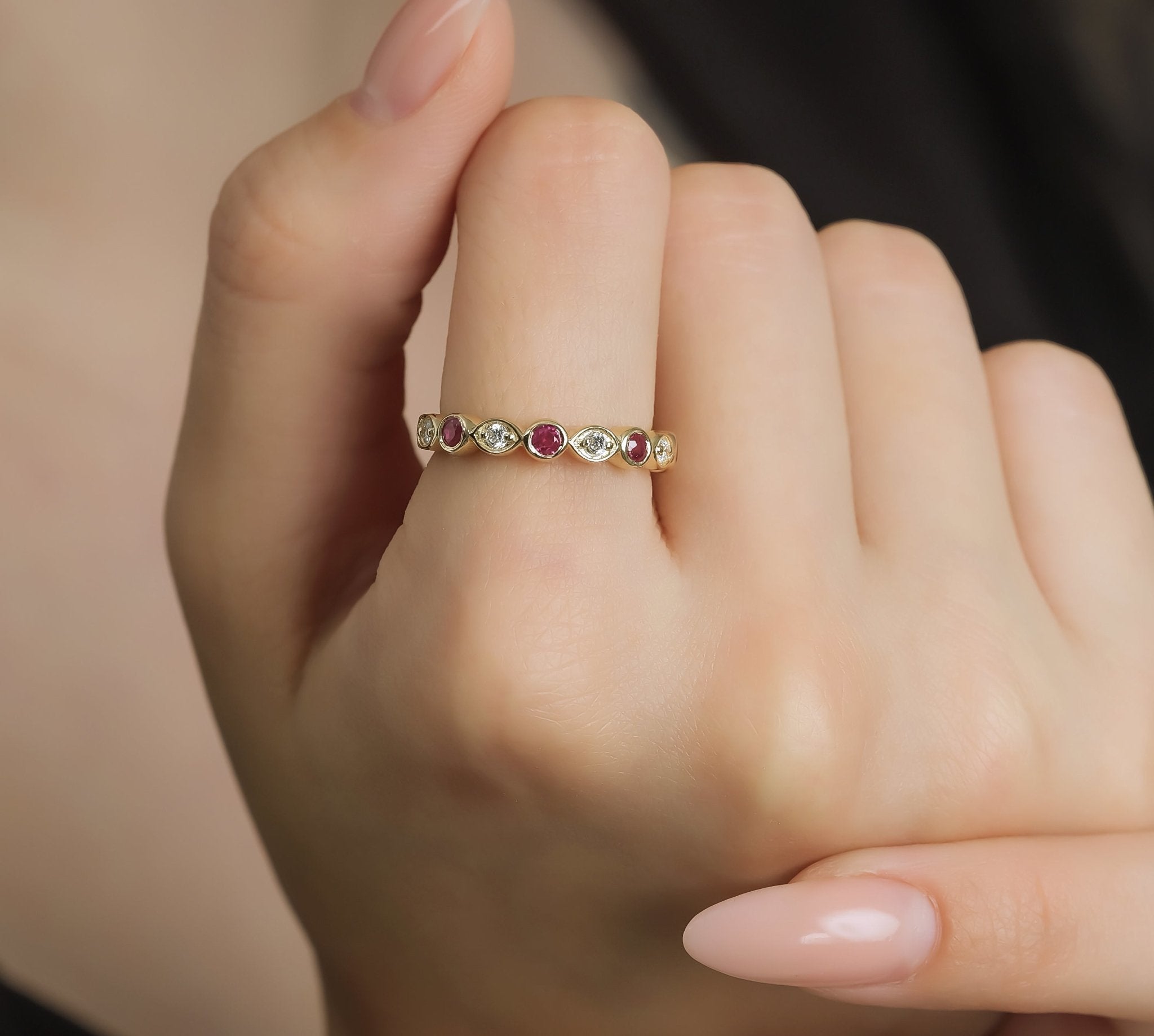 14K yellow gold wedding ring featuring round rubies and diamonds, showcased on a hand with neatly manicured nails.