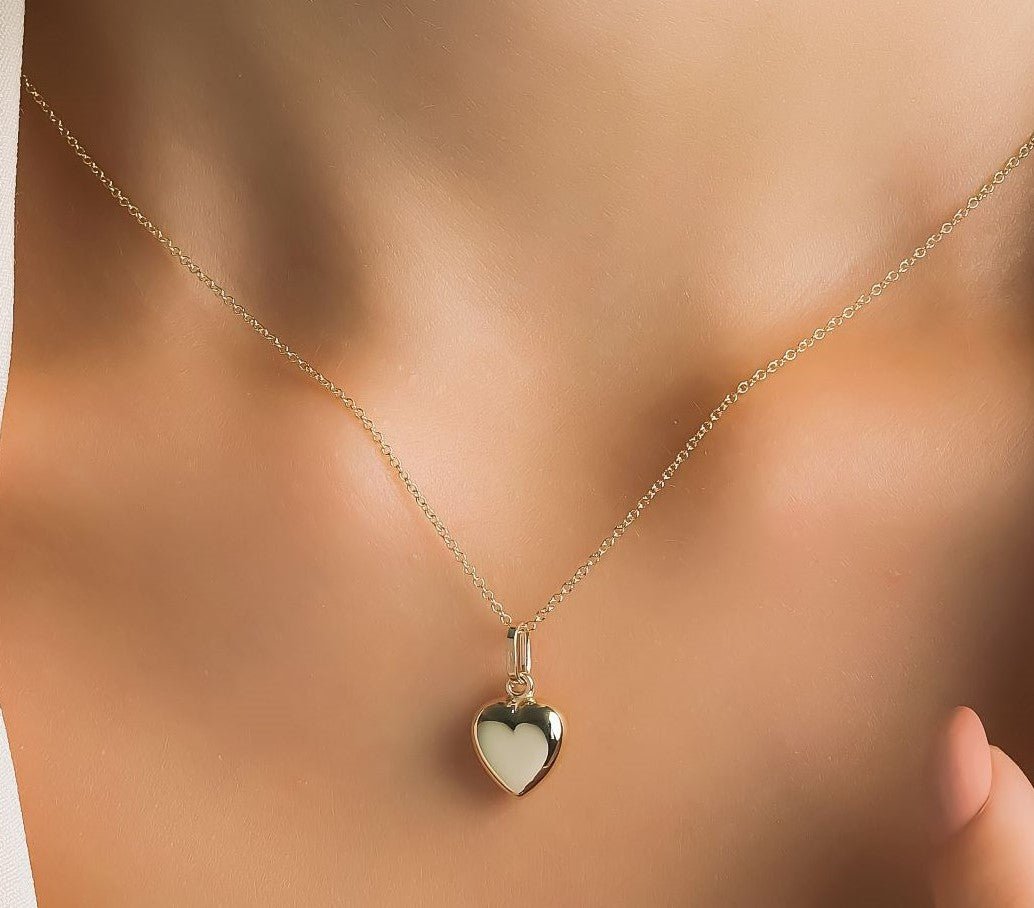 14K yellow gold shiny puffed heart necklace worn on a woman's neck, showcasing a delicate design perfect for everyday use.