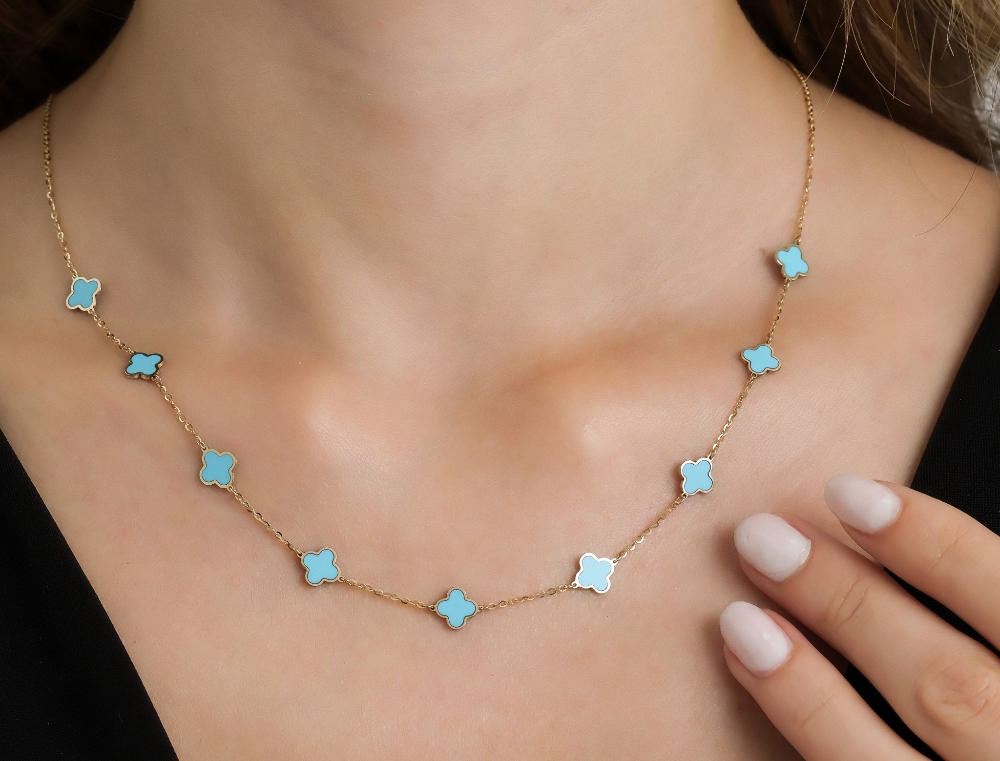 14K yellow gold station turquoise four leaf clover necklace worn elegantly on a model.