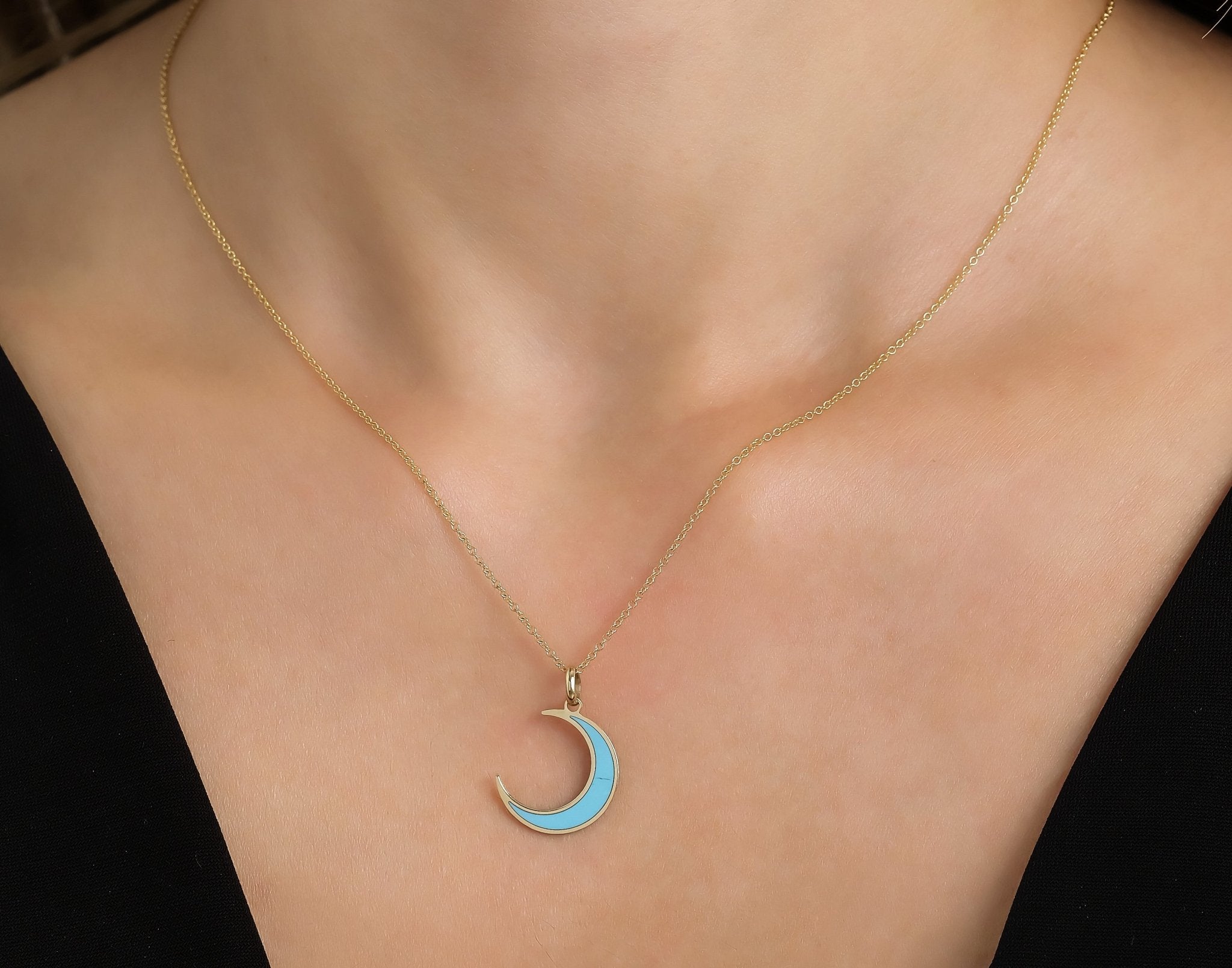 14K yellow gold crescent moon necklace with turquoise accent, elegantly worn on a model's neck.